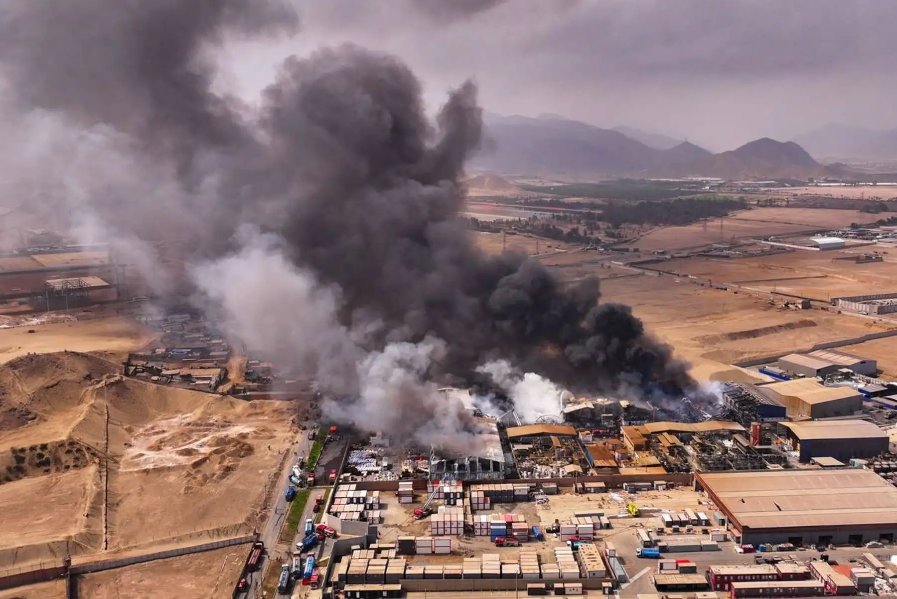 El trabajo de los bomberos se mantiene en la zona industrial de Lurín, donde el incendio generó una extensa columna de humo y severos daños materiales. Foto: Ricardo Cuba.
