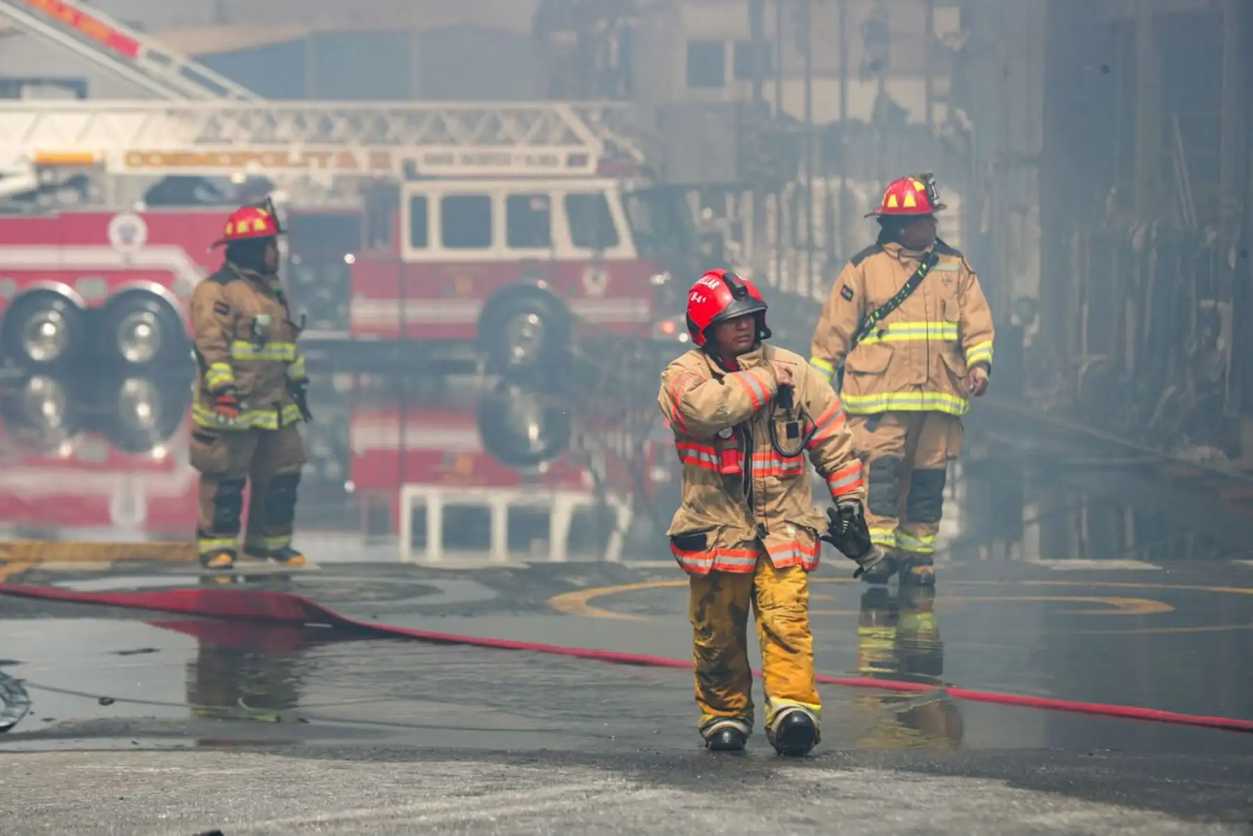 Hombres de rojo permanecen en la zona de emergencia para evitar que el fuego se reactive y se propague a otros ambientes de la planta afectada. Foto: Ricardo Cuba.