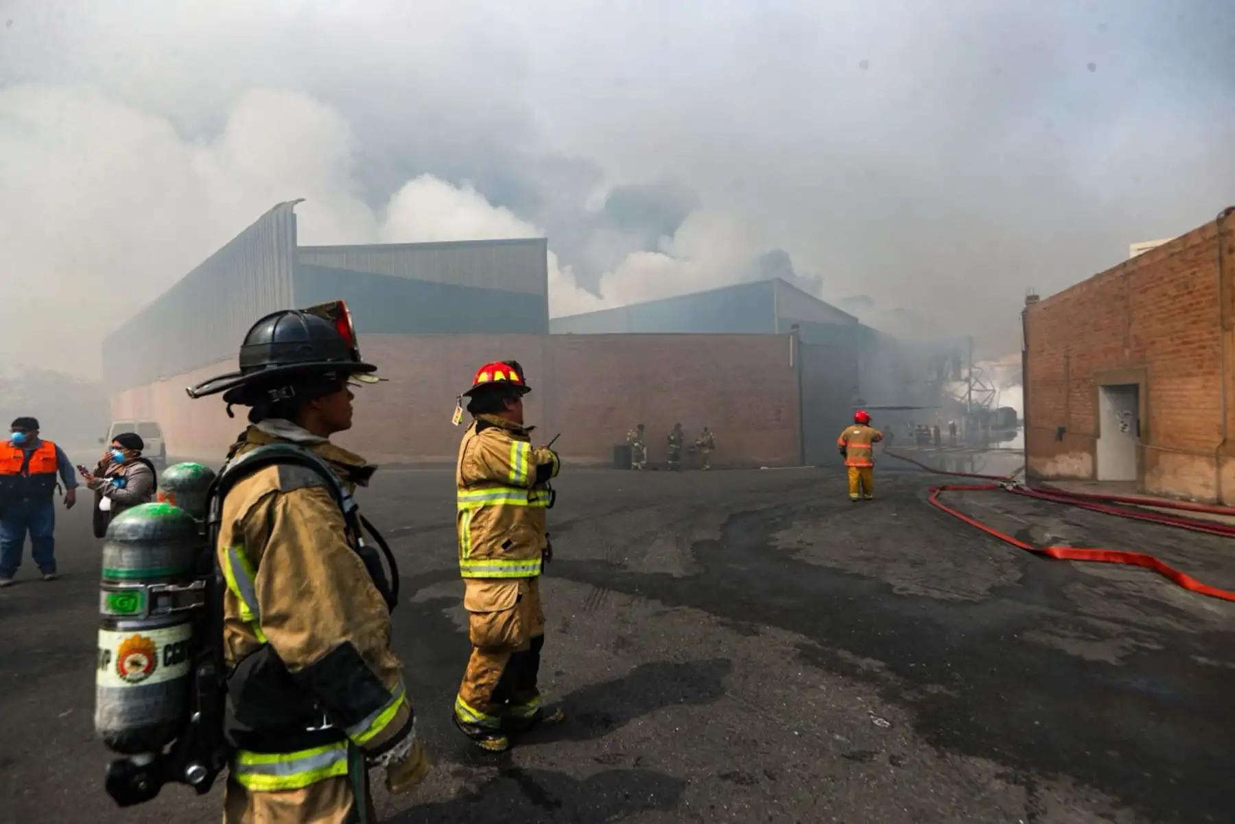 Bomberos avanzan entre el humo para continuar las tareas de control y enfriamiento en la zona afectada por el incendio industrial. Foto: Ricardo Cuba.