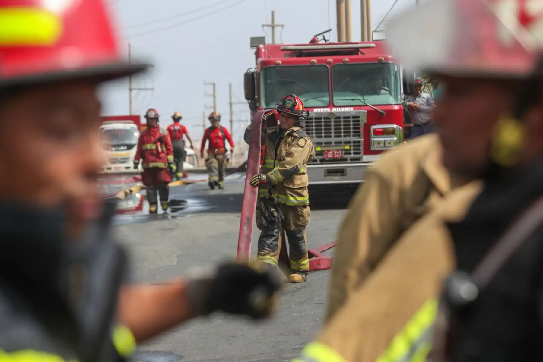 Bomberos y personal de emergencia coordinan nuevas acciones para contener el siniestro, considerado uno de los más complejos registrados en la zona industrial de Lurín. Foto: Ricardo Cuba.