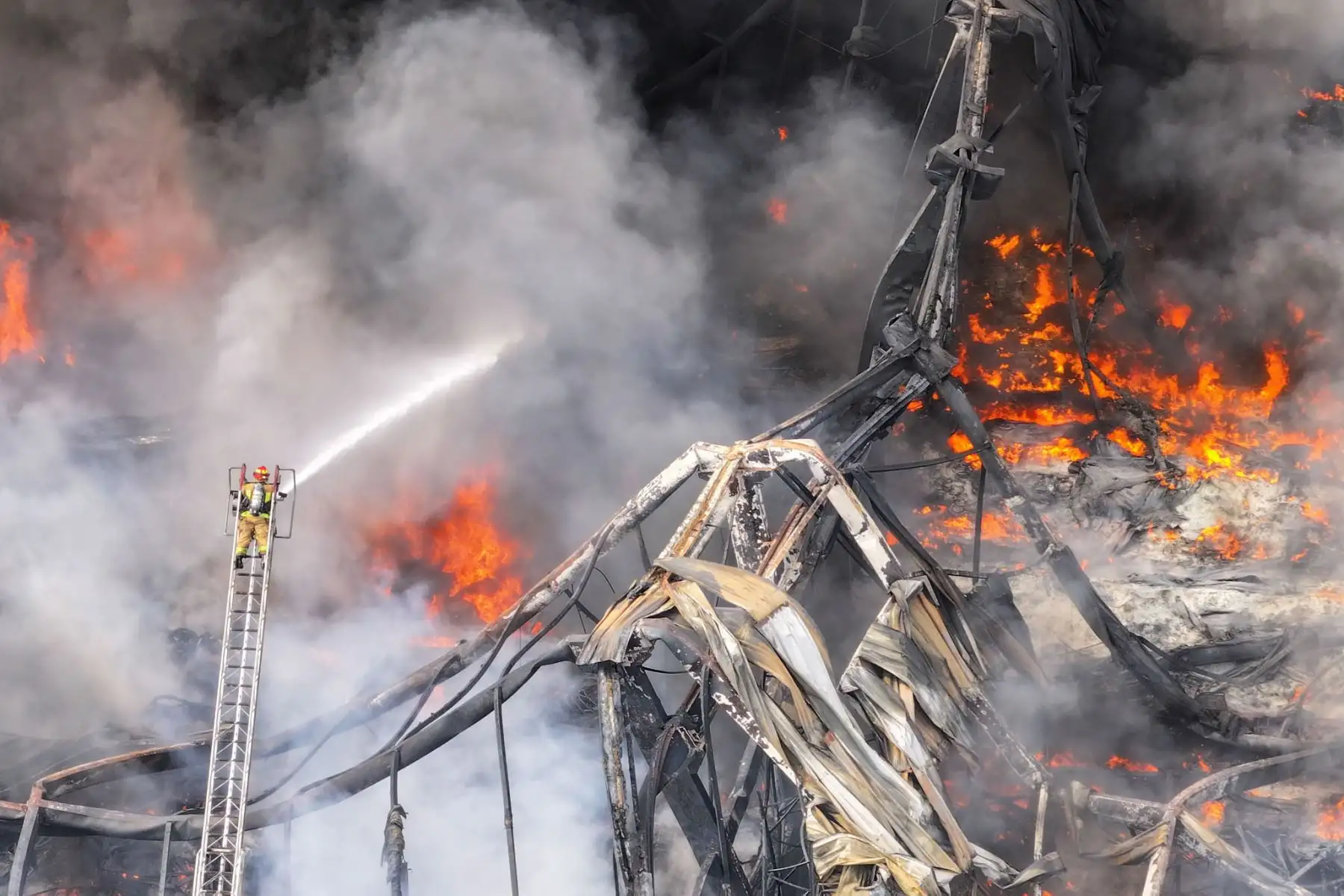 Las llamas y el humo evidencian la magnitud del incendio que afectó una fábrica en Lurín, donde los bomberos mantienen labores de enfriamiento y control. Foto: Ricardo Cuba.