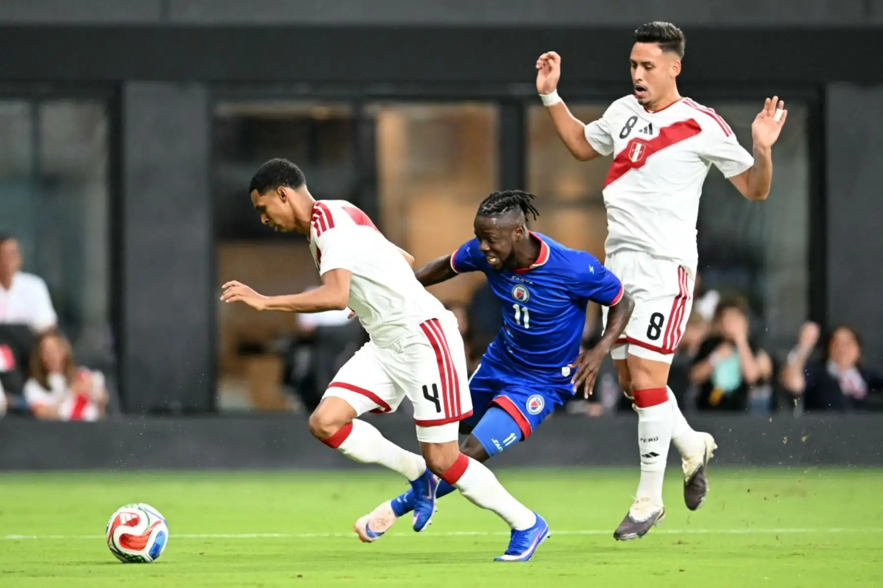 El delantero haitiano número 11, Louicius Don Deedson (C), disputa el balón con el defensor peruano número 04, Marcos López (I), y el defensor peruano número 08, Erick Noriega, durante el partido amistoso internacional de fútbol entre Haití y Perú en el Estadio Nu de Miami, Florida, el 5 de junio de 2026. (Foto de CHANDAN KHANNA / AFP)