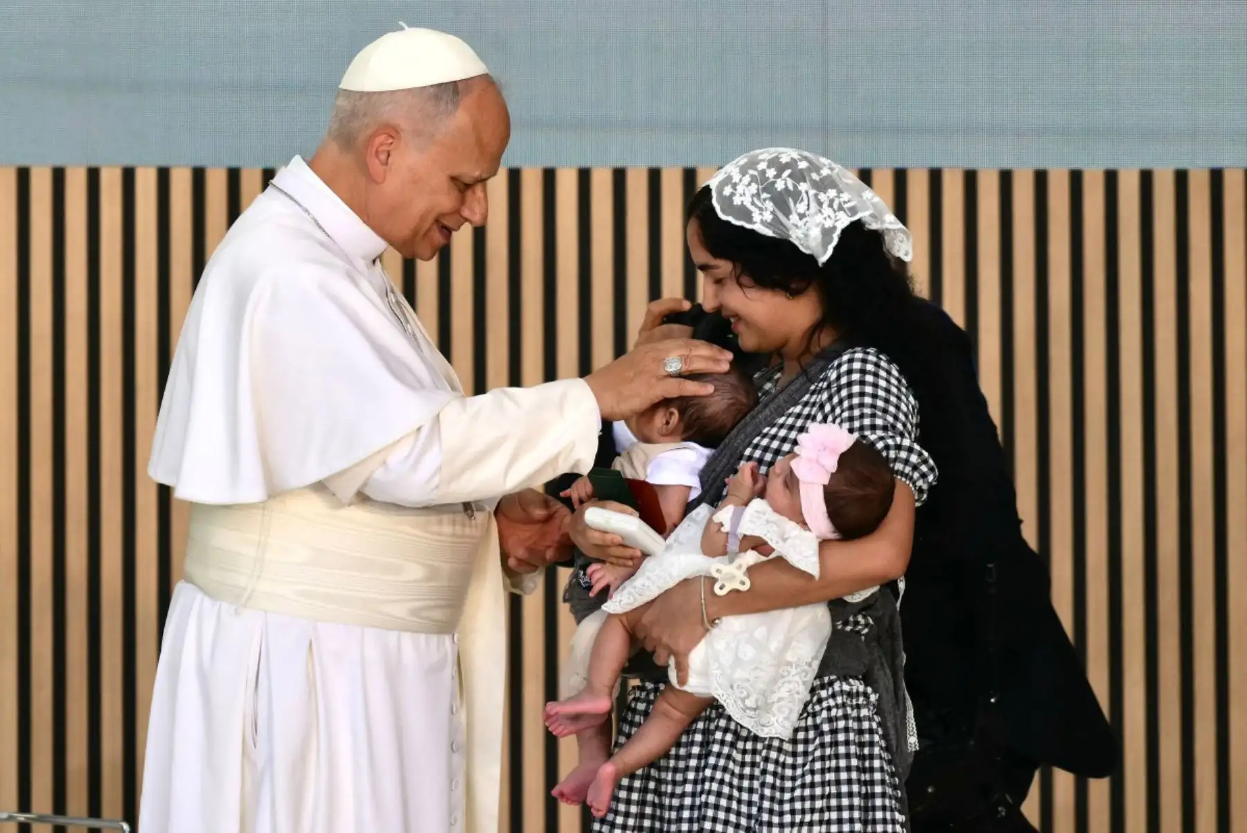 El papa León XIV bendice a los bebés de la cubana Niurka durante su visita al centro de acogida para personas sin hogar “Cedia 24 horas” de la organización benéfica Cáritas, en el barrio de Lucero, Madrid. El papa León XIV visita España del 6 al 12 de junio, con paradas en Madrid, Barcelona y las Islas Canarias, donde se reunirá con migrantes y organizaciones dedicadas a ayudarlos. Foto: ANDINA/AFP