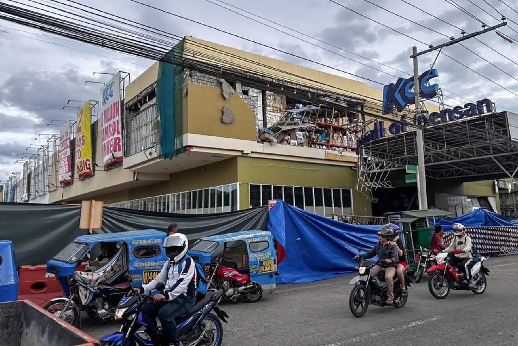 Los automovilistas pasan junto a un edificio dañado tras un terremoto de magnitud 7,8 en General Santos en Filipinas. AFP