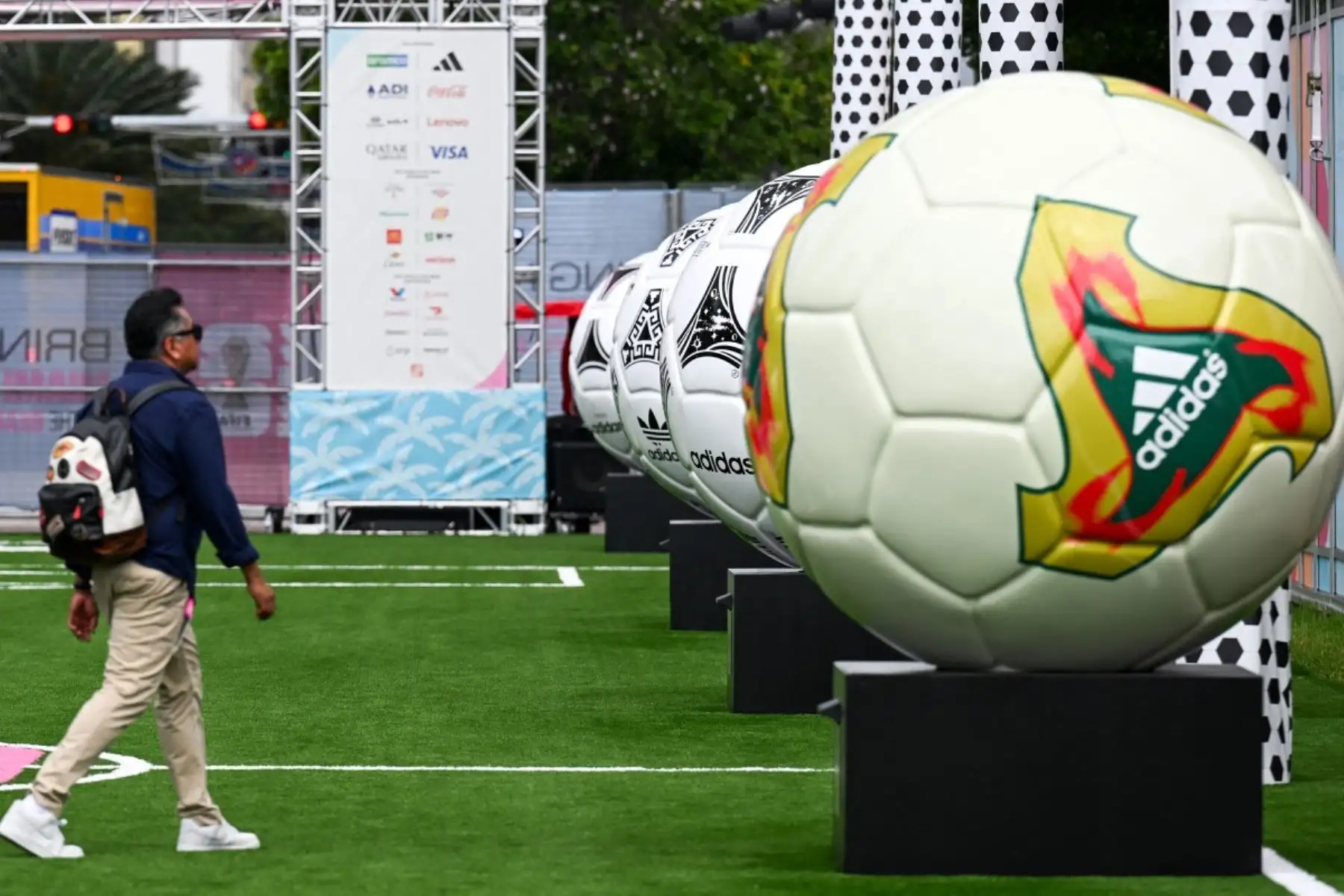 Un asistente camina cerca de maquetas de fútbol a gran escala antes de la inauguración del FIFA Fan Festival Miami, previo al Mundial de Fútbol de 2026 que se celebrará en Miami, Florida. AFP