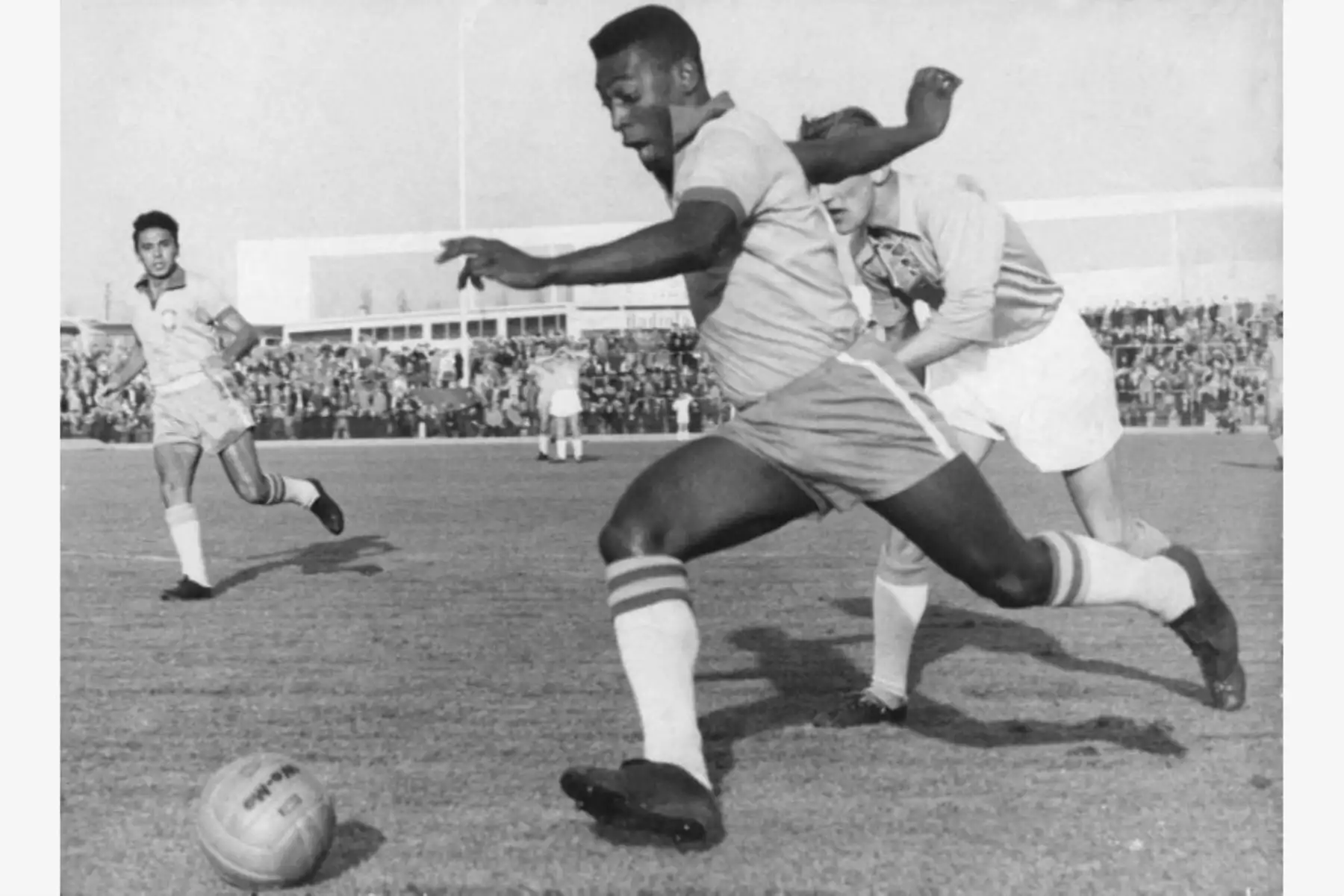 El delantero brasileño Pelé corre con el balón superando a un defensor del club sueco Malmö FF, disputado en Suecia, el 8 de mayo de 1960. Foto: AFP