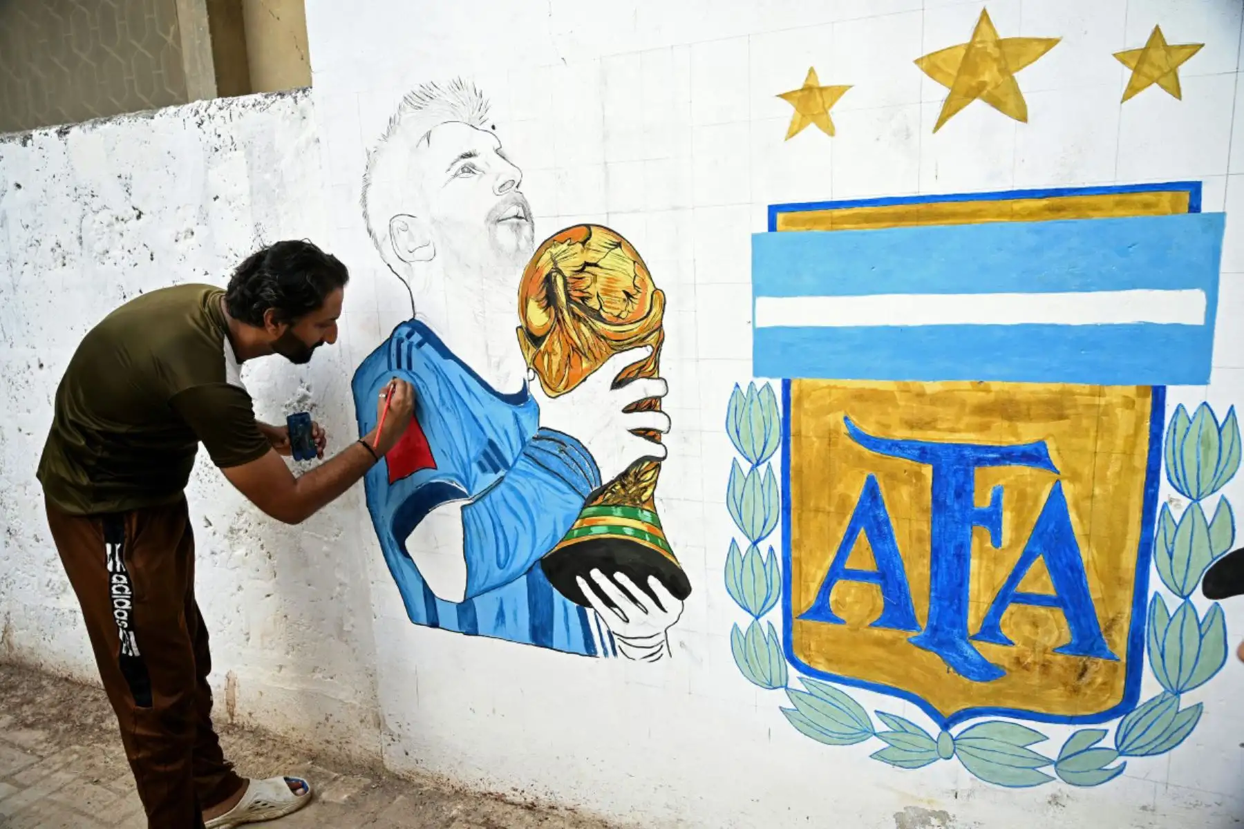 Un aficionado al fútbol pinta un mural en una calle de Karachi (Pakistán) con motivo de la Copa Mundial de la FIFA 2026. Foto: AFP