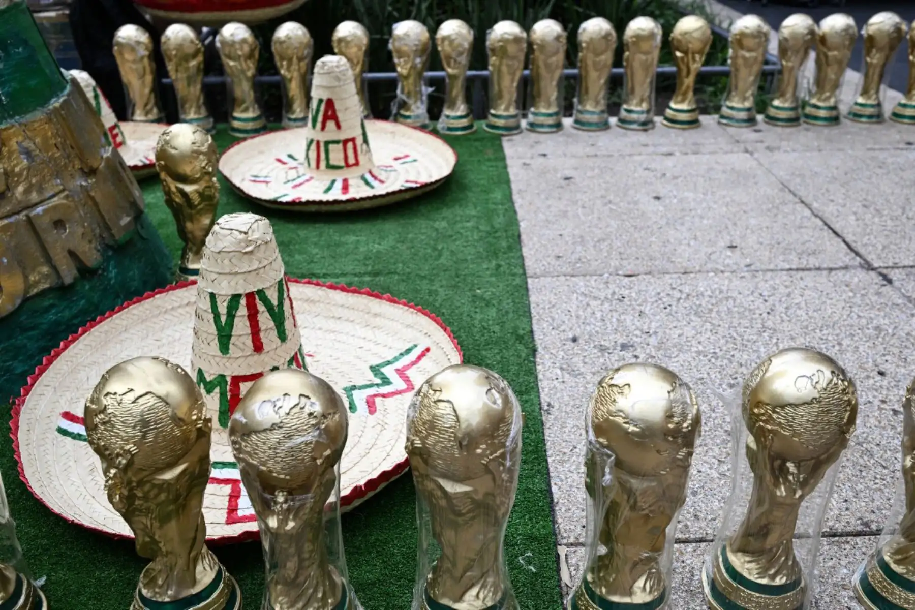 Recuerdos con forma del trofeo de la Copa Mundial de la FIFA y sombreros mexicanos tradicionales se exhiben para la venta en una calle de la Ciudad de México. Foto: AFP