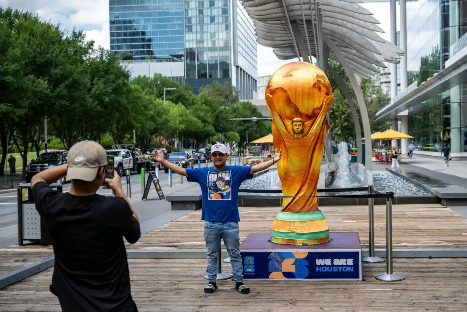Un hombre posa para una foto junto a una réplica del trofeo de la Copa Mundial en el centro de Houston, Texas,  antes de la inauguración de la Copa Mundial de la FIFA 2026. Foto: AFP