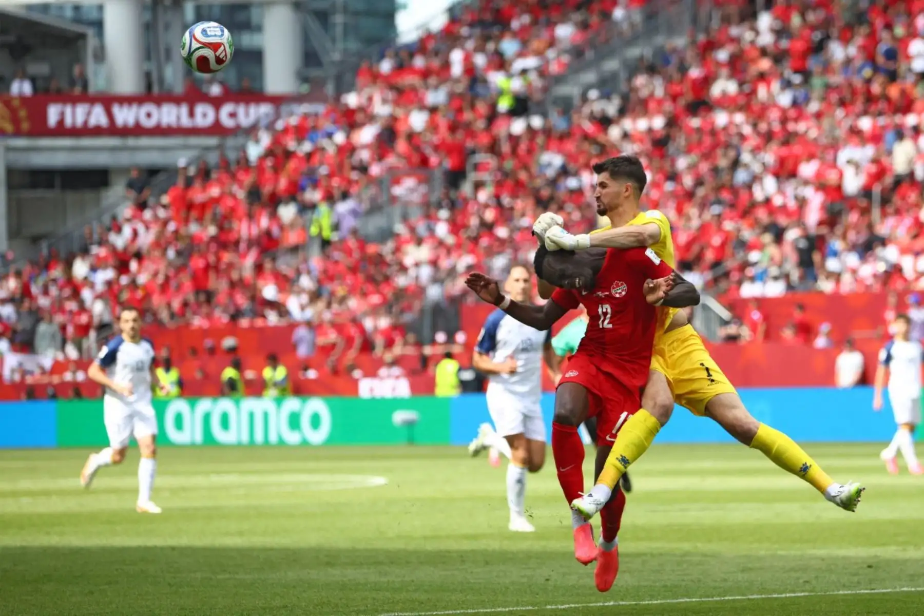 El portero de Bosnia-Herzegovina #01 Nikola Vasilj (R) boxea la pelota frente al delantero de Canadá #12 Tani Oluwaseyi durante el partido de fútbol del Grupo B de la Copa Mundial de 2026 entre Canadá y Bosnia y Herzegovina en el Estadio de Toronto en Toronto el 12 de junio de 2026. (Foto de Cole Burston / AFP)