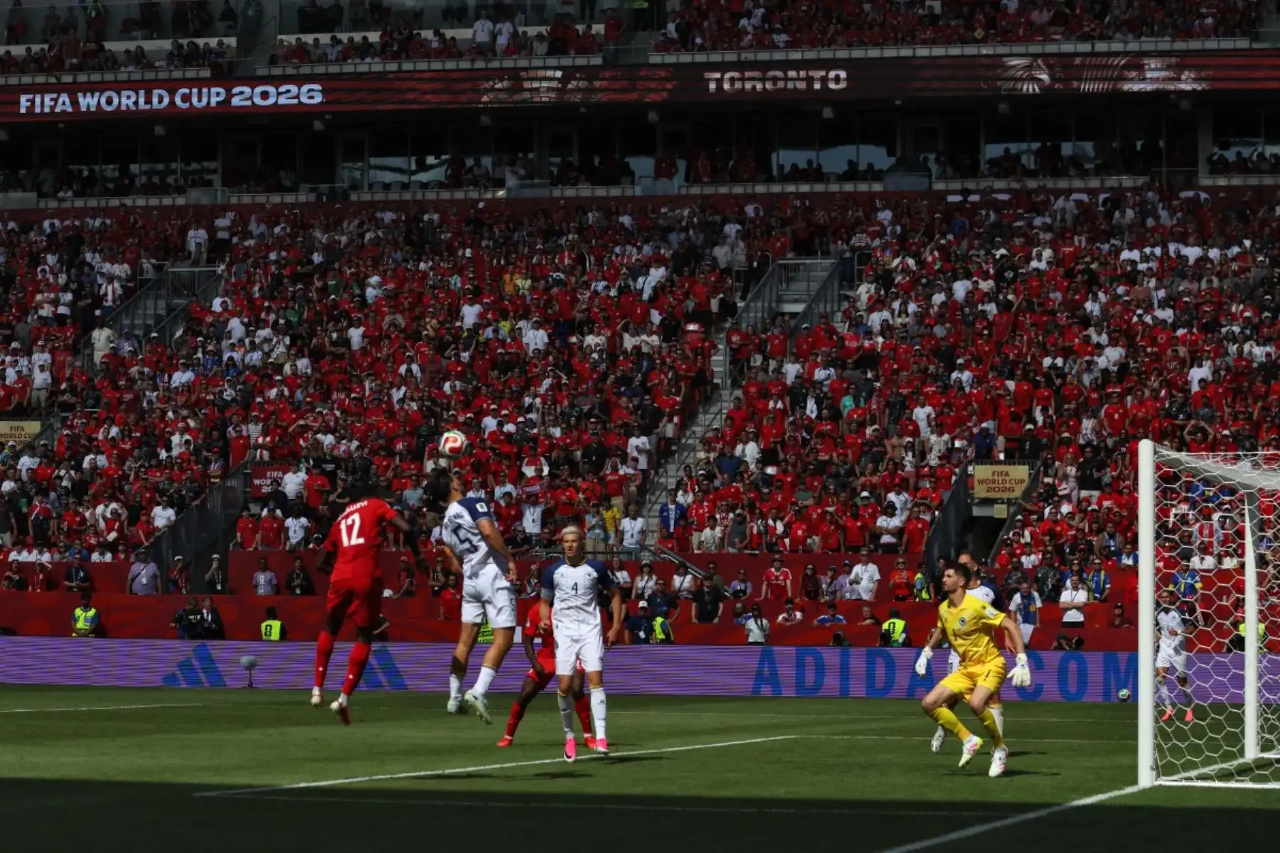 El delantero de Canadá #12 Tani Oluwaseyi (L) lucha por el balón con el defensor de Bosnia-Herzegovina #05 Sead Kolasinac (2ndL) durante el partido de fútbol del Grupo B de la Copa Mundial de 2026 entre Canadá y Bosnia y Herzegovina en el Estadio de Toronto en Toronto el 12 de junio de 2026. (Foto de Cole Burston / AFP)