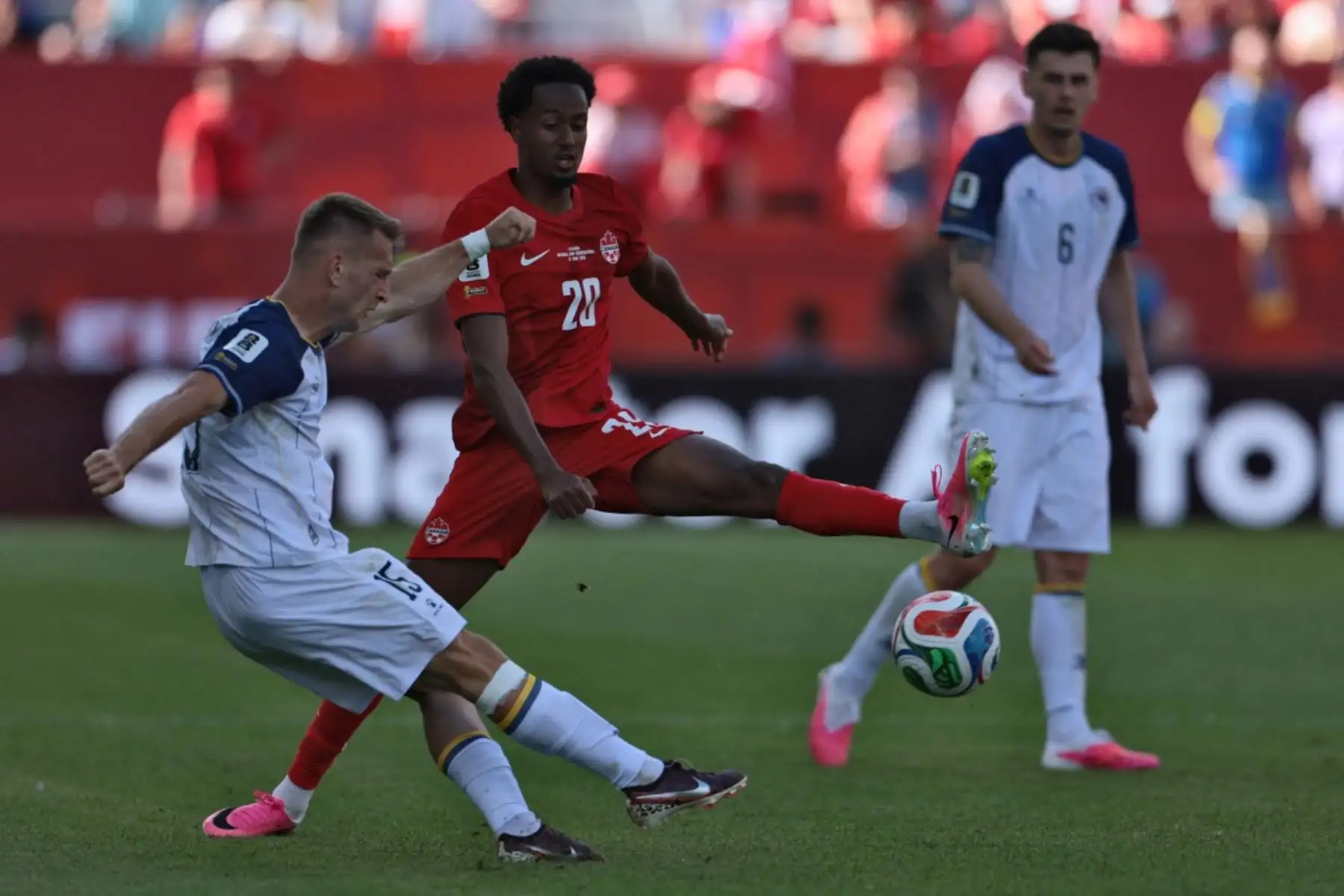 El delantero #15 de Bosnia-Herzegovina Amar Memic (L) lucha por el balón con el centrocampista canadiense #20 Ali Ahmed durante el partido de fútbol del Grupo B de la Copa Mundial 2026 entre Canadá y Bosnia y Herzegovina en el Estadio de Toronto en Toronto el 12 de junio de 2026. (Foto de Cole Burston / AFP)