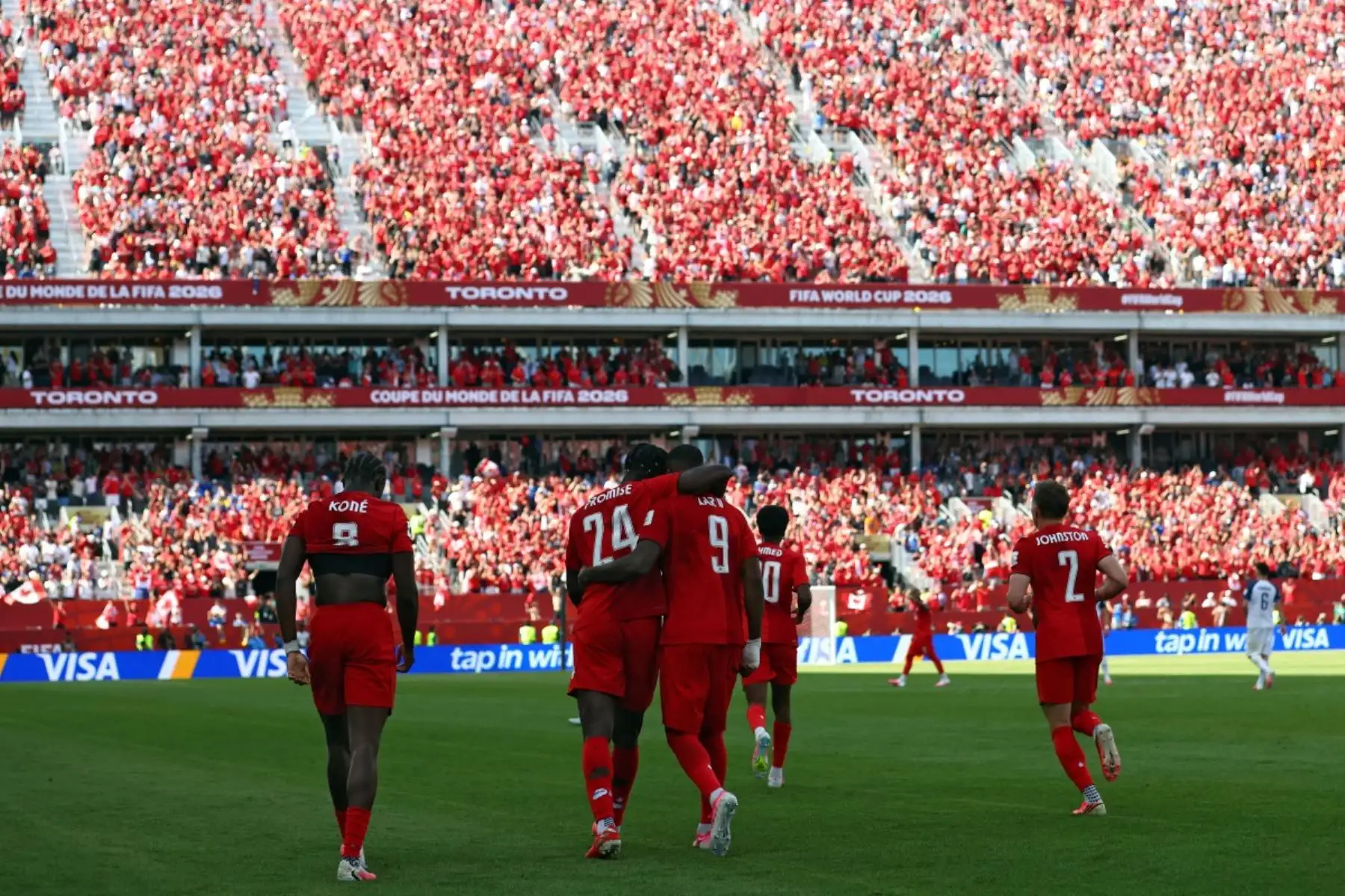 El delantero de Canadá #09 Cyle Larin (C,R) es felicitado por el delantero de Canadá #24 Promise David (C,L) después de marcar un gol durante el partido de fútbol del Grupo B de la Copa Mundial de 2026 entre Canadá y Bosnia y Herzegovina en el Estadio de Toronto en Toronto el 12 de junio de 2026. (Foto de Cole Burston / AFP)