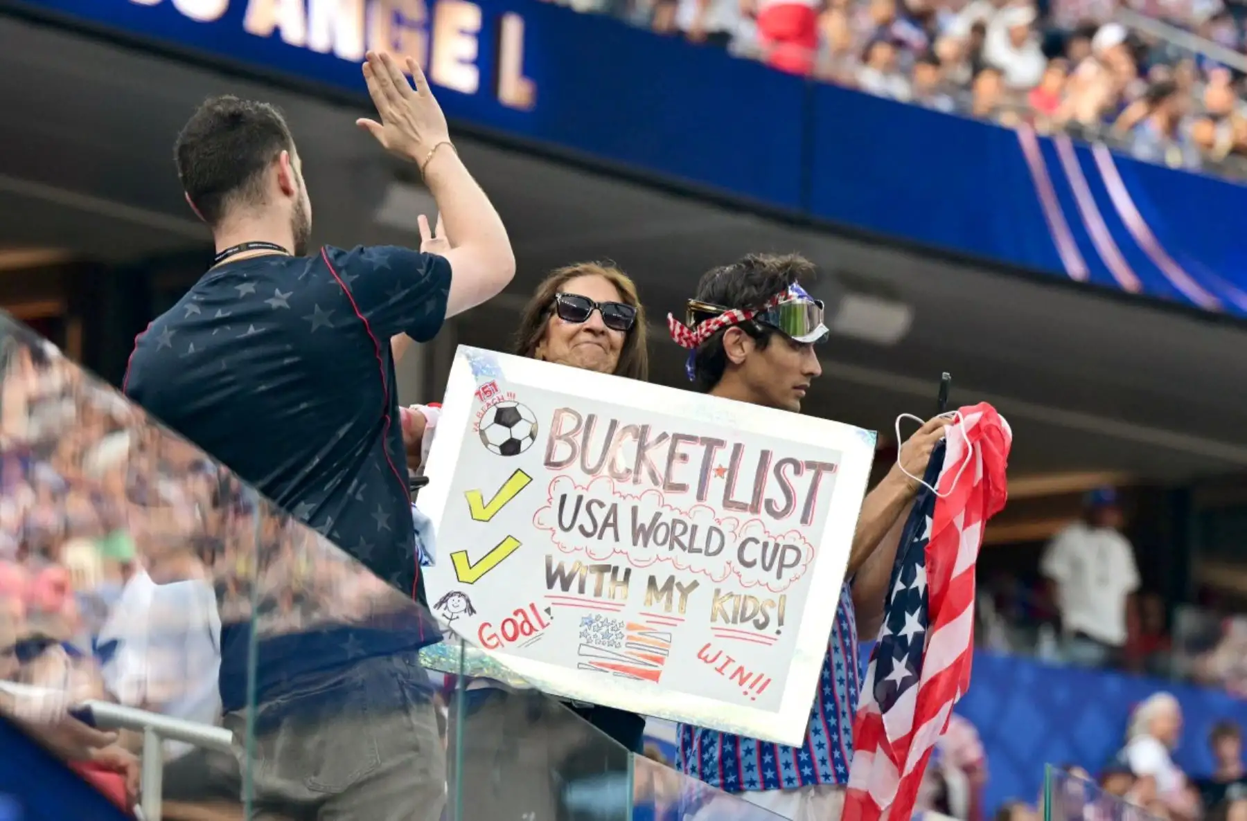 Una mujer sostiene una pancarta durante la ceremonia de apertura del Mundial de Fútbol de 2026, antes del partido del Grupo D entre Estados Unidos y Paraguay en el Estadio de Los Ángeles en Inglewood, el 12 de junio de 2026. (Foto de Frederic J. BROWN / AFP)
