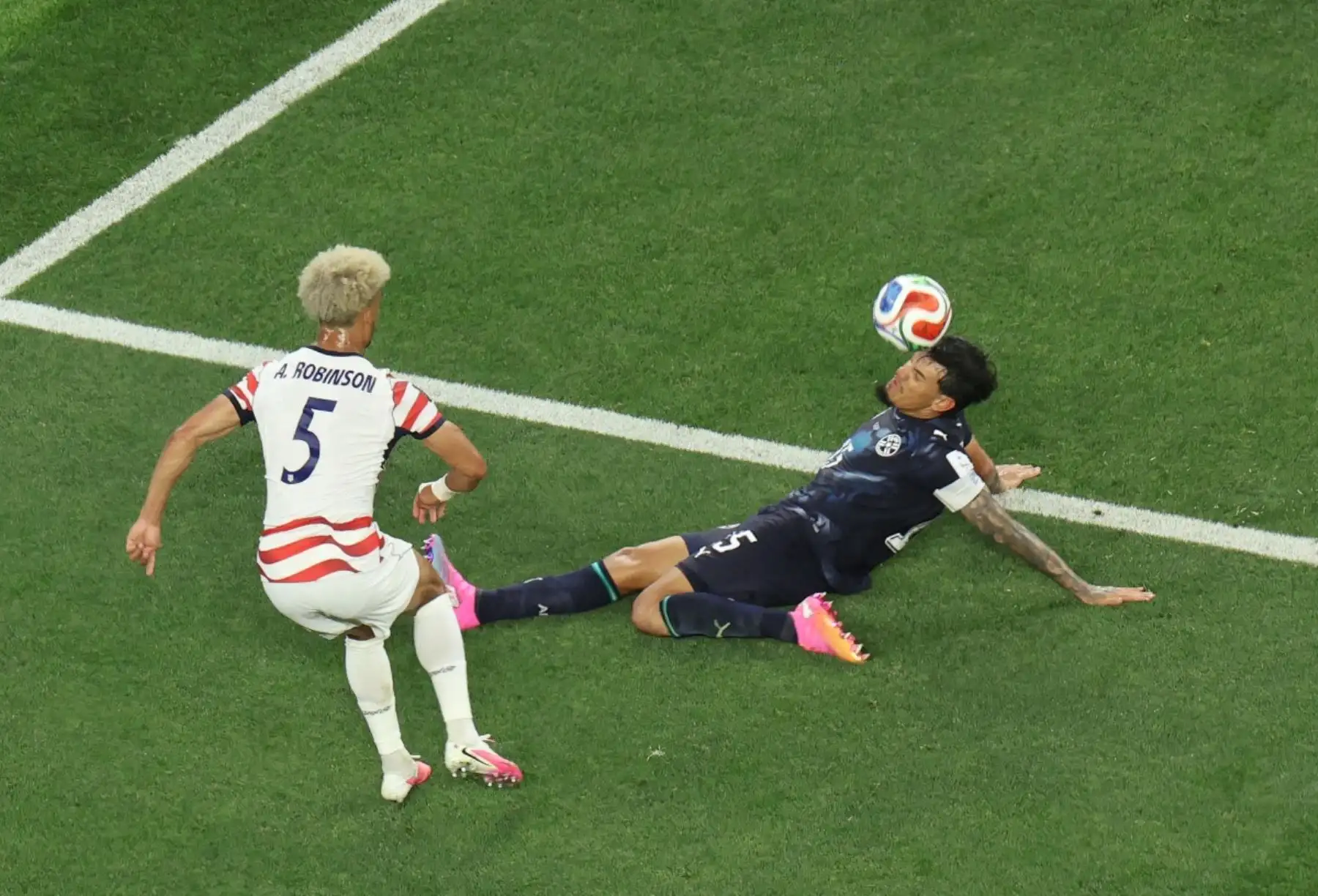 El defensa estadounidense Antonee Robinson (n.º 5) y el defensa paraguayo Gustavo Gómez (n.º 15) luchan por el balón durante el partido de fútbol del Grupo D del Mundial 2026 entre Estados Unidos y Paraguay en el Estadio de Los Ángeles en Inglewood el 12 de junio de 2026. (Foto de Valerie MACON / AFP)