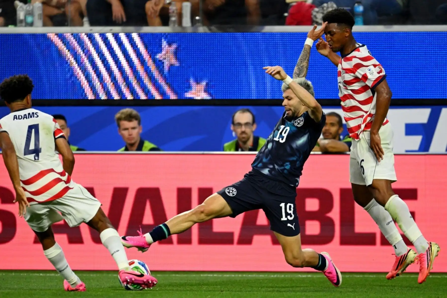 El centrocampista paraguayo Julio Enciso (C), número 19 del ranking, disputa el balón con el defensor estadounidense Alex Freeman (D), número 16, durante el partido de fútbol del Grupo D del Mundial 2026 entre Estados Unidos y Paraguay, disputado en el Estadio de Los Ángeles en Inglewood el 12 de junio de 2026. (Foto de Patrick T. Fallon / AFP)