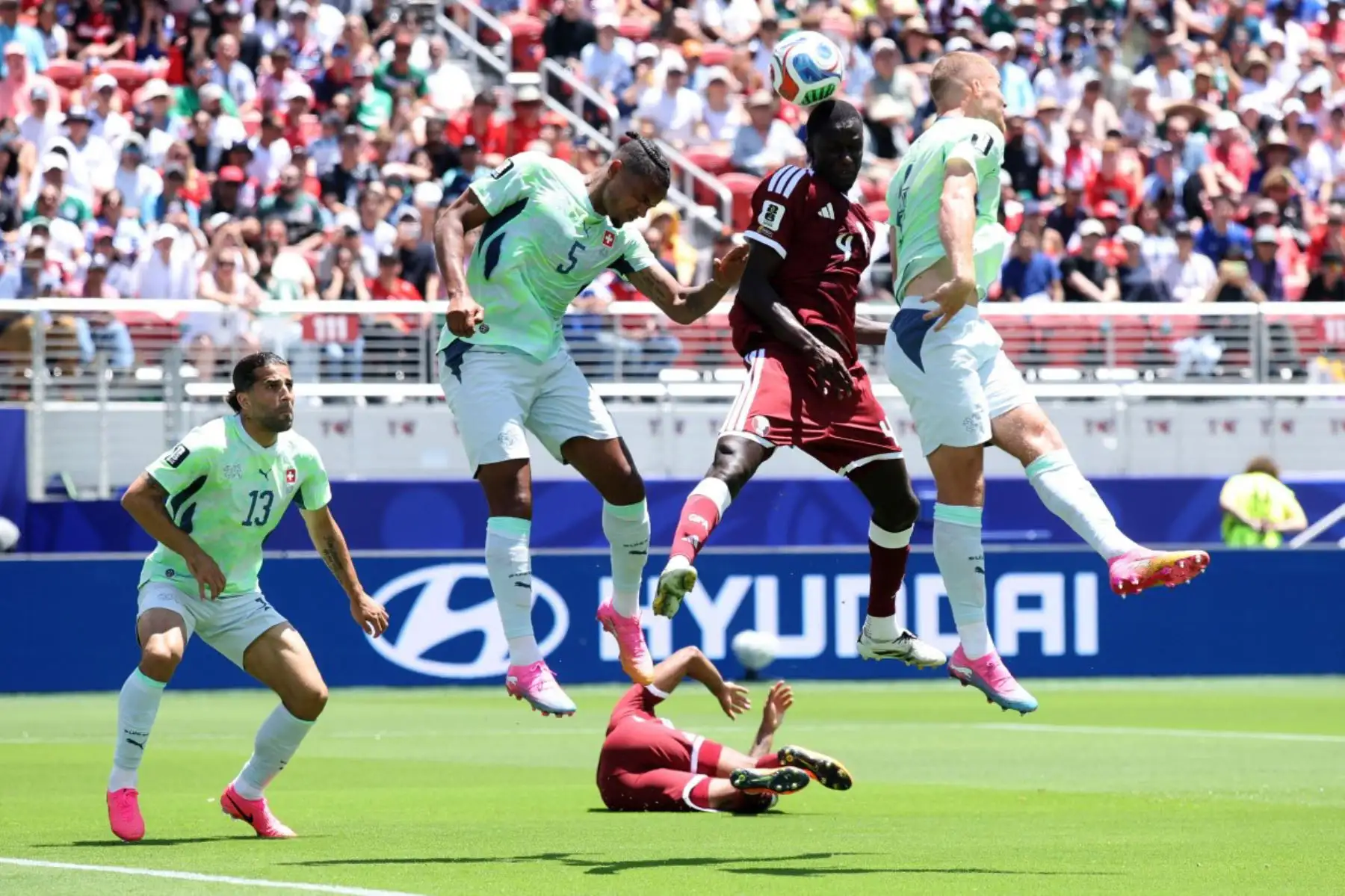 Issa Laye de Qatar cabecea el balón ante Manuel Akanji y Nico Elvedi de Suiza durante el partido del Grupo B de la Copa Mundial de la FIFA 2026 entre Qatar y Suiza en el Estadio del Área de la Bahía de San Francisco el 13 de junio de 2026 en California. Foto: Getty Images / AFP