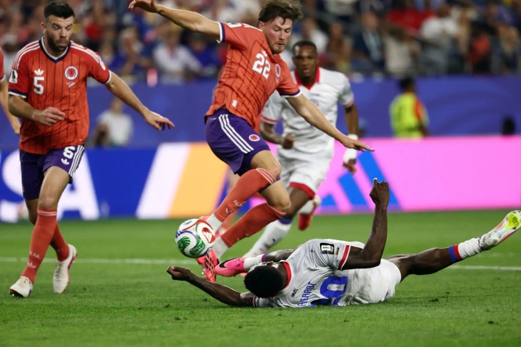El delantero haitiano Frantzdy Pierrot (abajo), número 20, y el defensa escocés Nathan Patterson, número 22, luchan por el balón durante el partido de fútbol del Grupo C de la Copa Mundial 2026 entre Haití y Escocia en el Boston Stadium de Foxborough el 13 de junio de 2026. (Foto de FRANCK FIFE / AFP)
