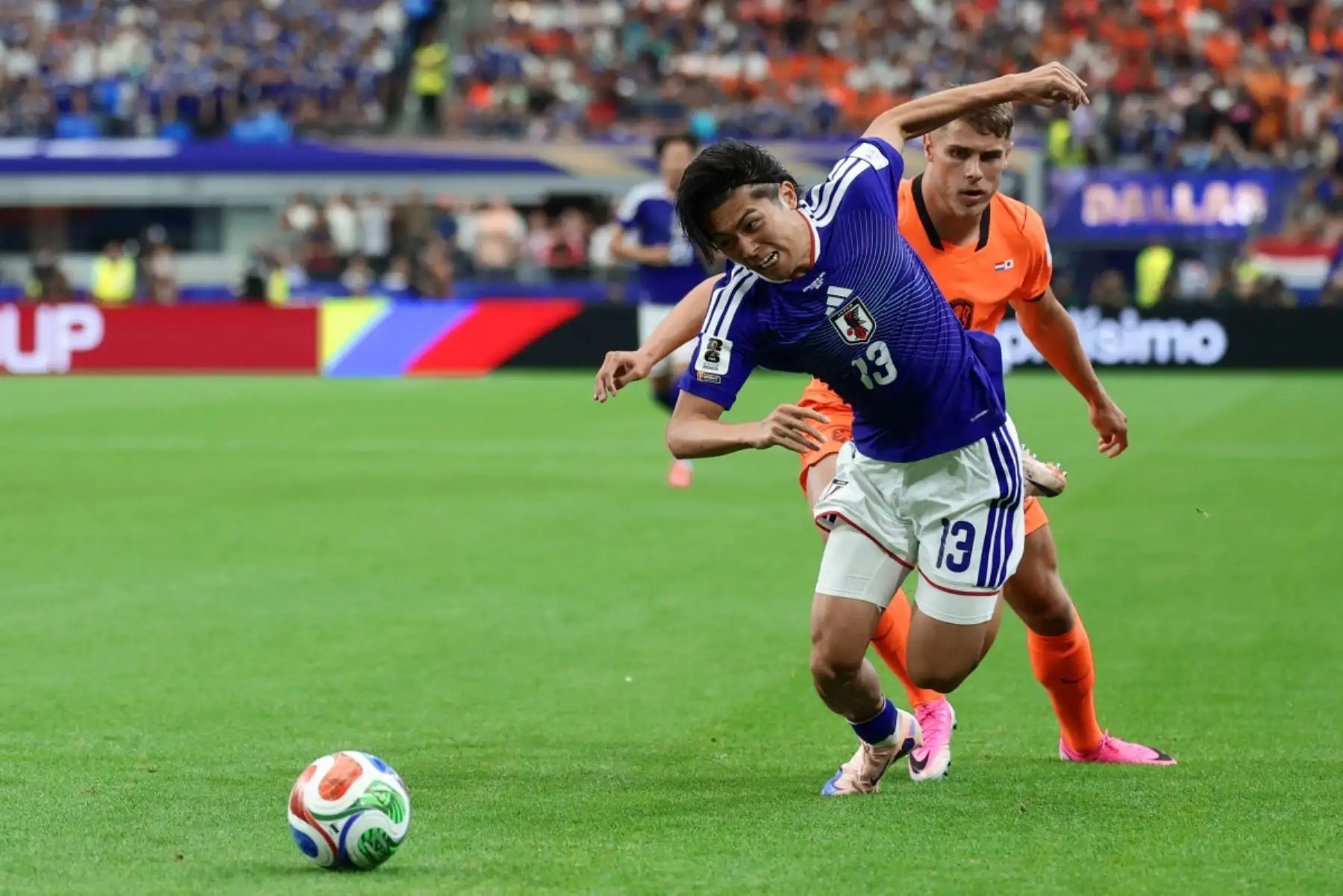 El centrocampista japonés Keito Nakamura (izq.), número 13, disputa el balón con el defensa neerlandés Micky Van de Ven, número 15, durante el partido de fútbol del Grupo F de la Copa Mundial 2026 entre Países Bajos y Japón en el estadio Dallas de Arlington el 14 de junio de 2026. (Foto de Aric Becker / AFP)