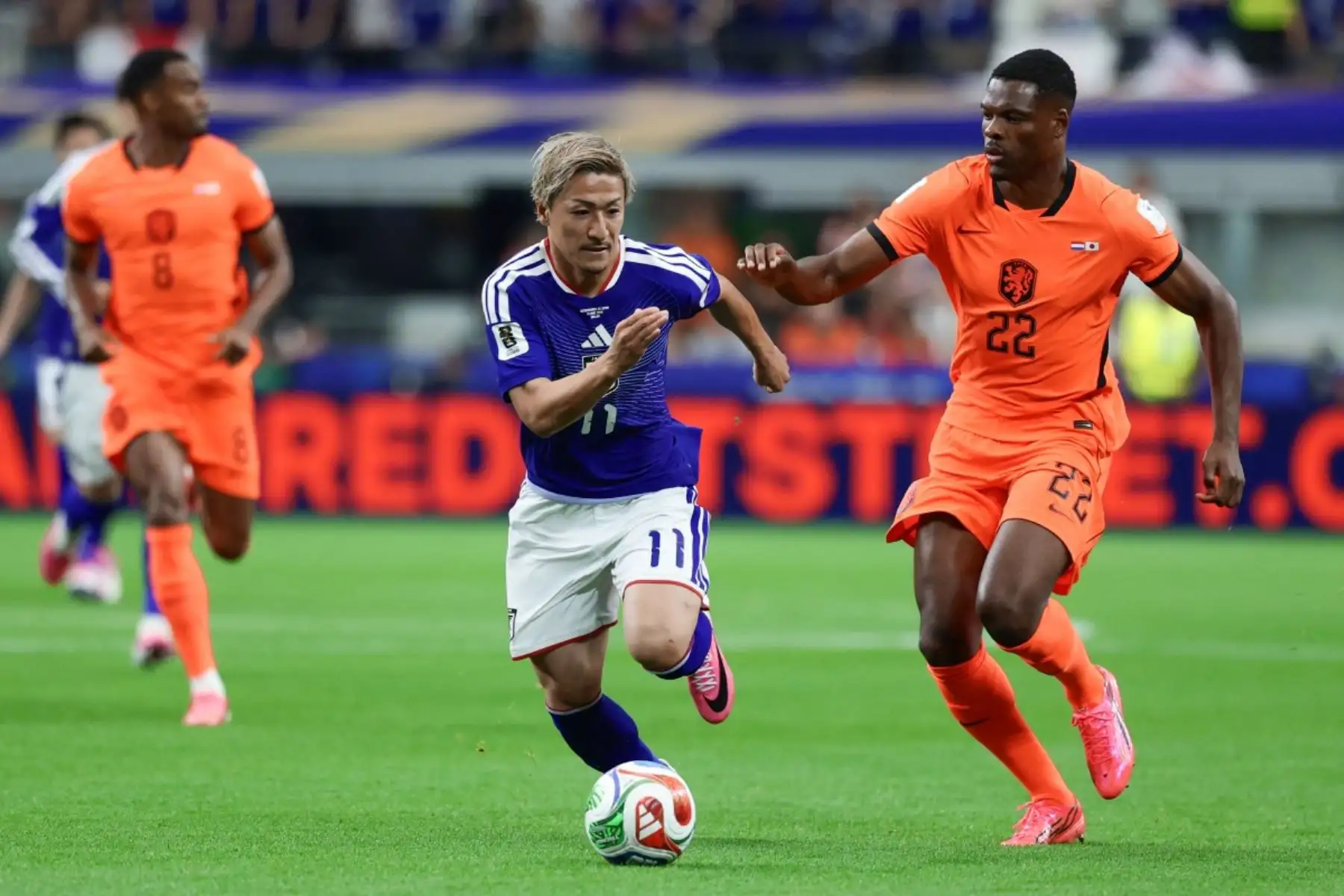 El delantero japonés Daizen Maeda (C), número 11, disputa el balón con el defensa neerlandés Denzel Dumfries (D), número 22, durante el partido de fútbol del Grupo F del Mundial de 2026 entre Países Bajos y Japón en el estadio Dallas de Arlington el 14 de junio de 2026. (Foto de Aric Becker / AFP)