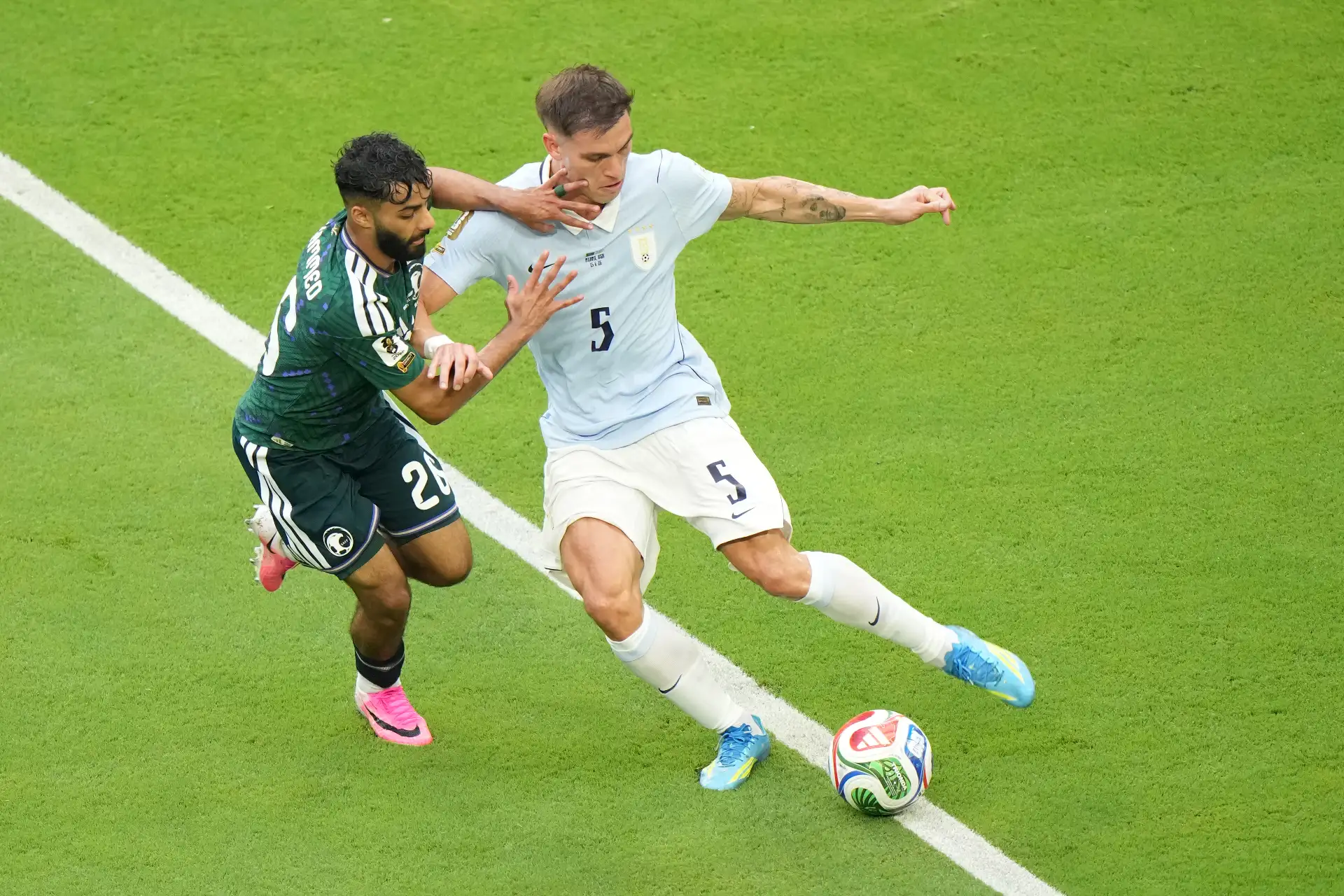 Mohammed Abu Alshamat de Arabia Saudita disputa el balón con Manuel Ugarte de Uruguay este lunes, en un partido del grupo H de la Mundial FIFA 2026 entre Arabia Saudita y Uruguay en el estadio Hard Rock en Miami. Foto: ANDINA/EFE