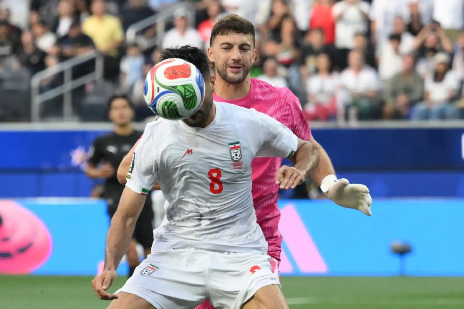 El centrocampista iraní, Mohammad Mohebbi, y el portero neozelandés, Max Crocombe, luchan por el balón durante el partido de fútbol del Grupo G de la Copa Mundial 2026 entre Irán y Nueva Zelanda. AFP