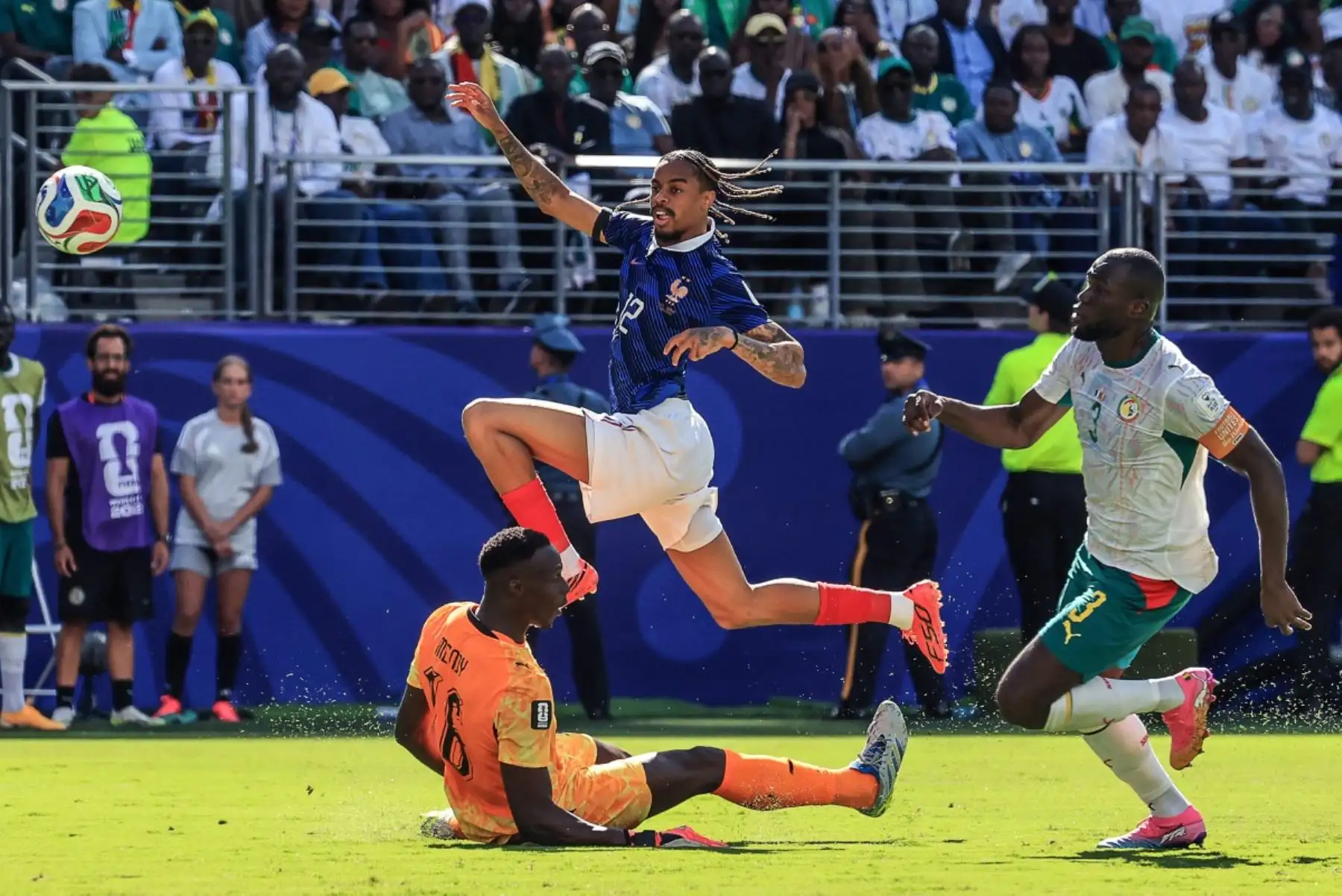 El delantero francés Bradley Barcola, número 12, anota el segundo gol de su equipo ante el portero senegalés Edouard Mendy, número 16, durante el partido de fútbol del Grupo I de la Copa Mundial de 2026 entre Francia y Senegal en el estadio New York/New Jersey en East Rutherford el 16 de junio de 2026. (Foto de TIMOTHY A. CLARY / AFP)