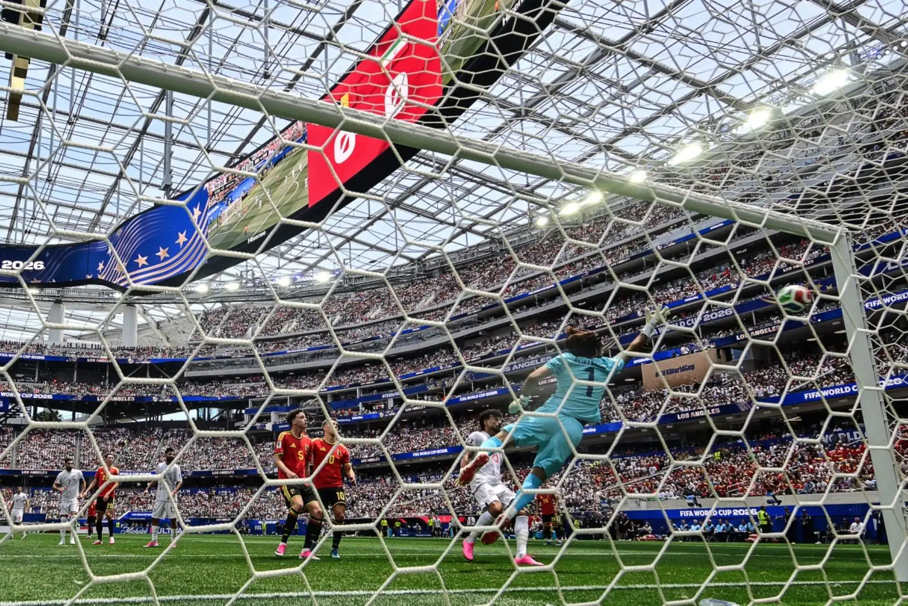 El portero iraní Alireza Beiranvand (número 1) observa el balón mientras el delantero belga Dodi Lukebakio (número 14, fuera de plano) falla una oportunidad durante el partido de fútbol del Grupo G de la Copa Mundial 2026 entre Bélgica e Irán en el Estadio de Los Ángeles en Inglewood el 21 de junio de 2026. (Foto de Frederic J. Brown / AFP)