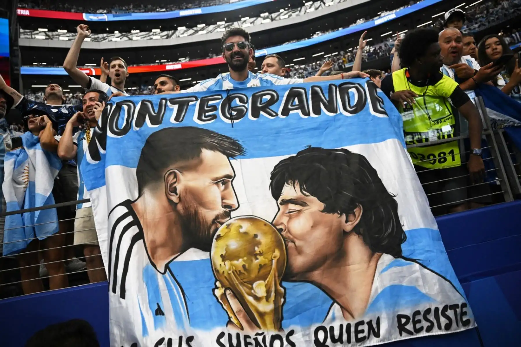 Un aficionado argentino mostró una imagen de Diego Maradona y Lionel Messi junto a la Copa del Mundo, símbolos de dos generaciones del fútbol albiceleste. Foto: ANDINA/AFP.