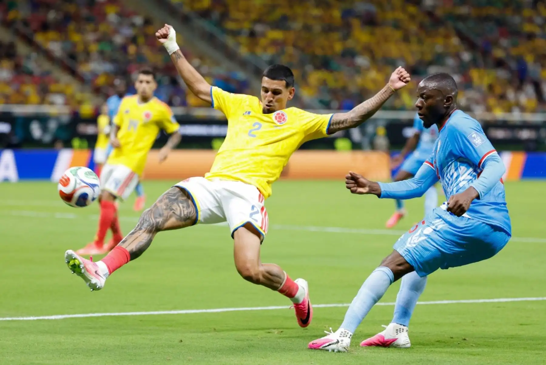 El defensa colombiano Daniel Muñoz (número 2) y el centrocampista de la República Democrática del Congo, Edo Kayembe (número 25), disputan el balón durante el partido de fútbol del Grupo K del Mundial 2026 entre Colombia y la República Democrática del Congo en el Estadio Guadalajara de Zapopan, el 23 de junio de 2026. (Foto de Ulises Ruiz / AFP)