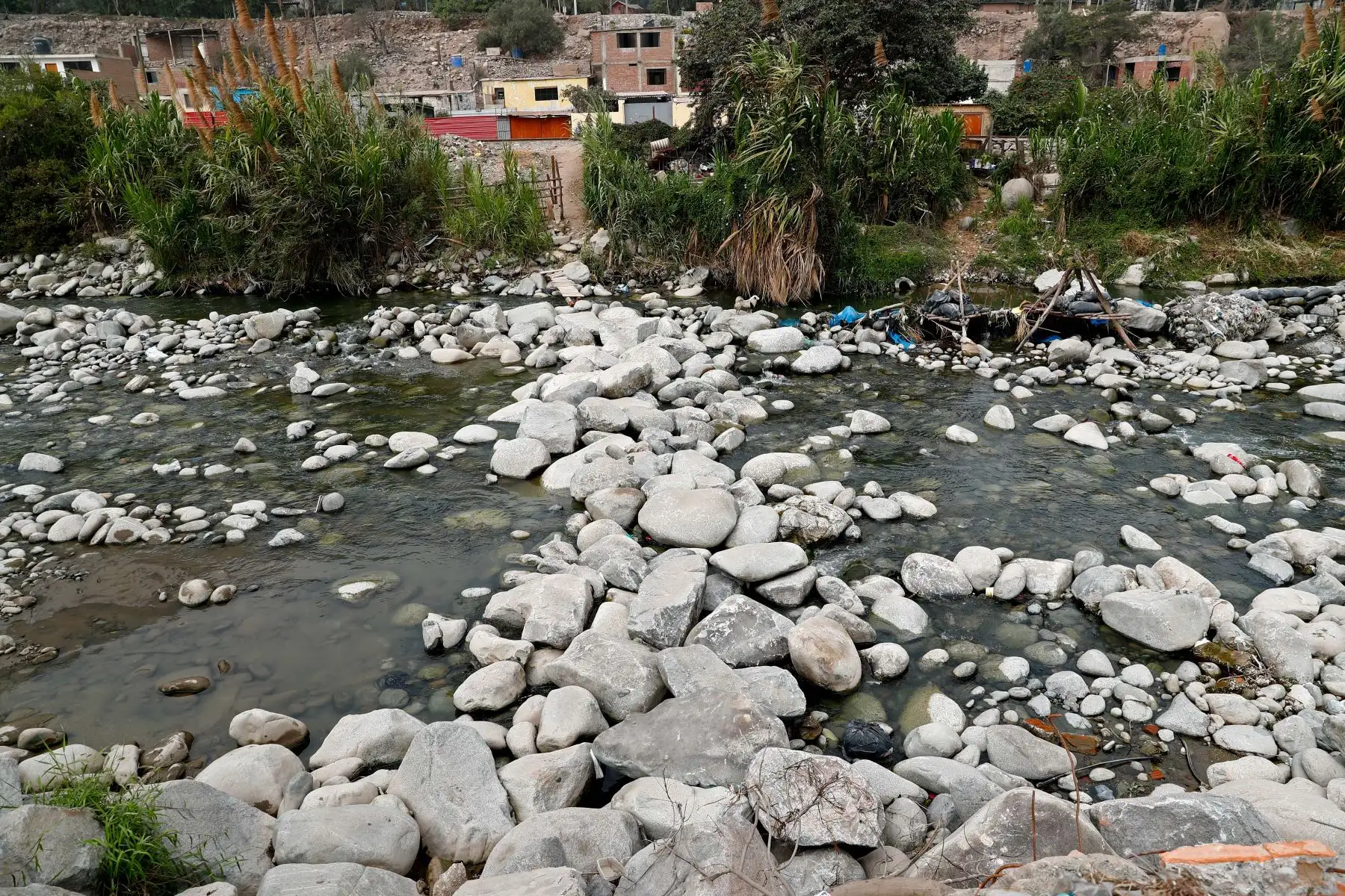 Hace 10 años, los vecinos de las zonas de Baja California y Campanillas en Chosica perdieron su puente peatonal sobre el río tras un colapso. Ante. La necesidad de trasladarse de un lado a otro, se organizaron y construyeron artesanalmente un paso sobre el río hecho a base de grandes bloques de piedra. Indeci supervisó la zona ante la próxima llegada del fenómeno de El Niño. Foto: ANDINA/Daniel Bracamonte