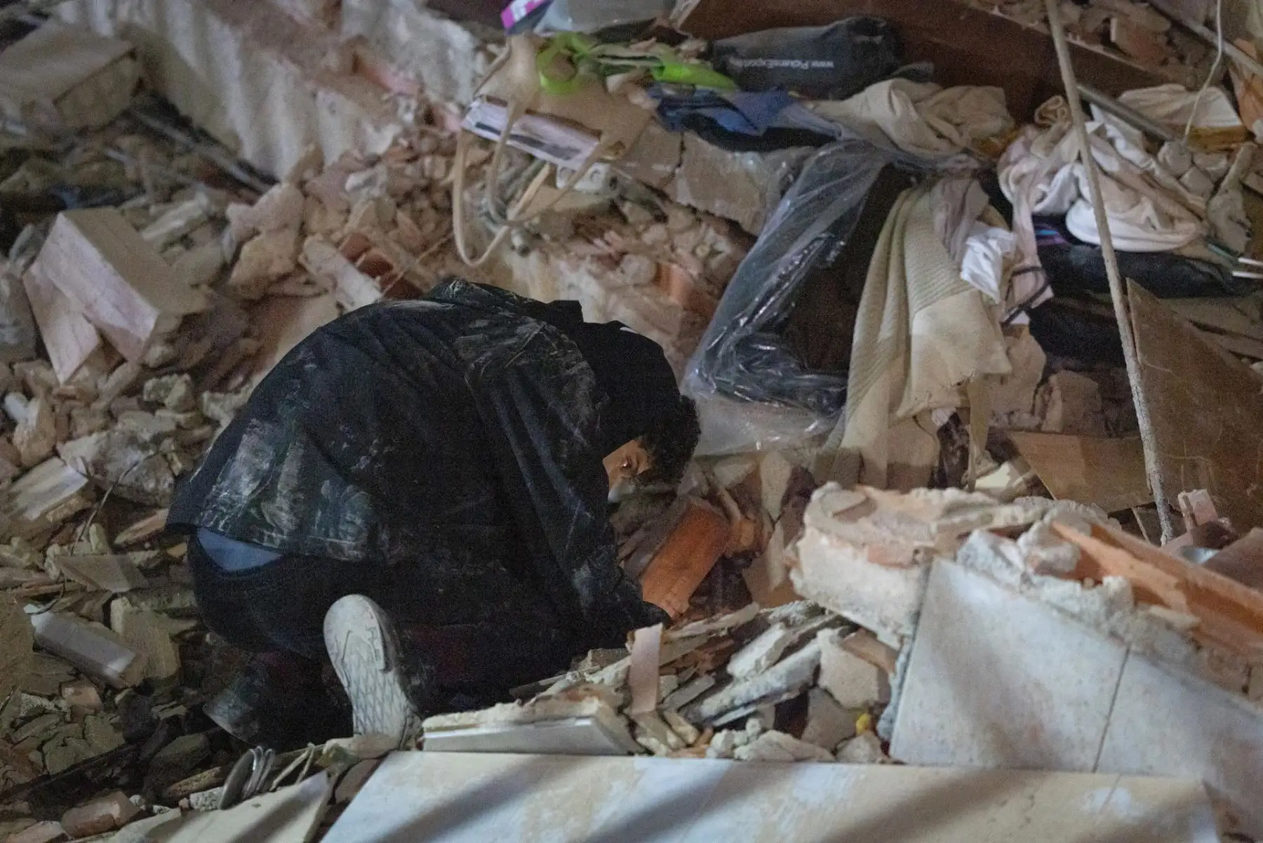 Una persona remueve restos de concreto y otros materiales durante la búsqueda de víctimas entre las estructuras colapsadas. Foto: ANDINA/AFP.