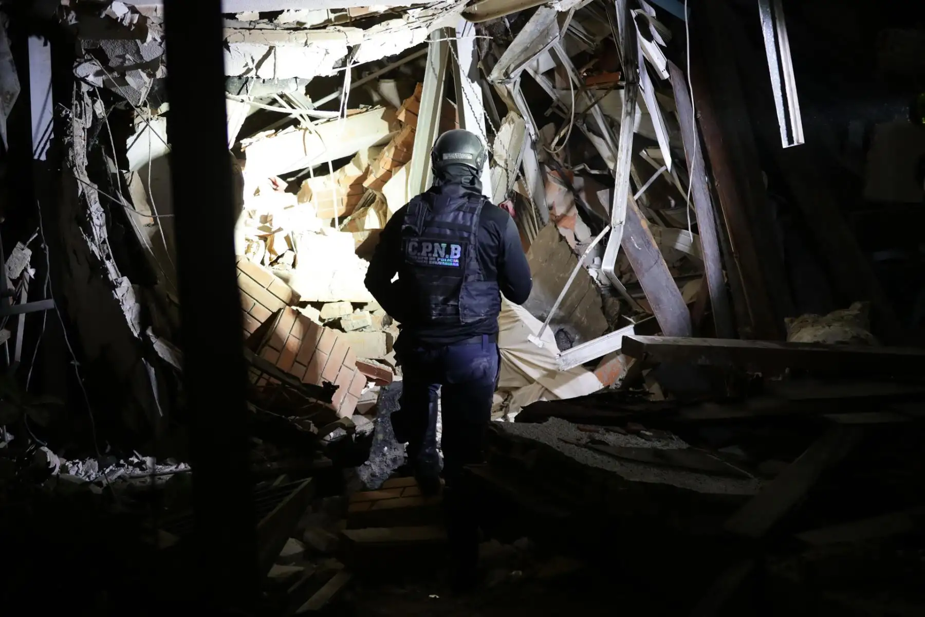 Un integrante de los equipos de emergencia inspecciona una zona destruida mientras continúan las labores de búsqueda y rescate. Foto: ANDINA/AFP.