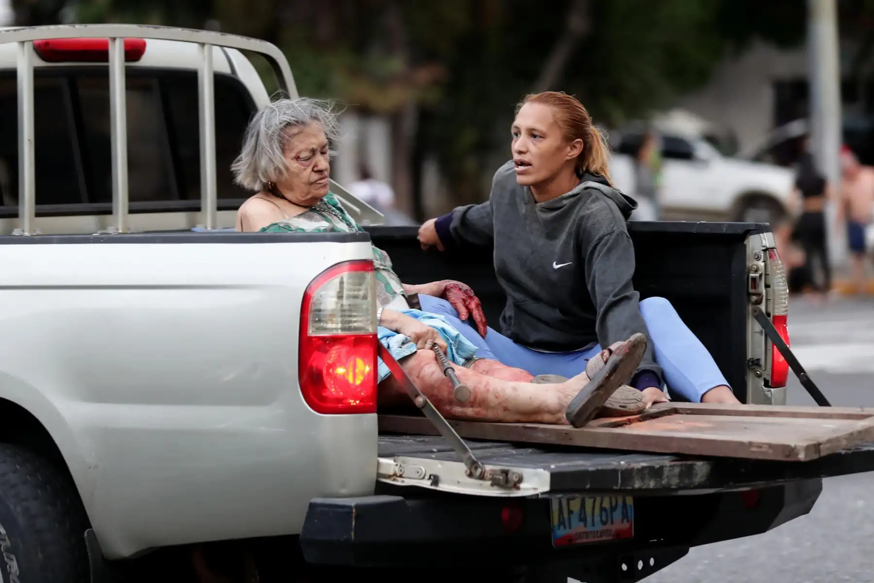 Una mujer es trasladada en la parte posterior de una camioneta tras los potentes sismos que dejaron al menos 164 muertos y 971 heridos en Venezuela. Foto: ANDINA/AFP.