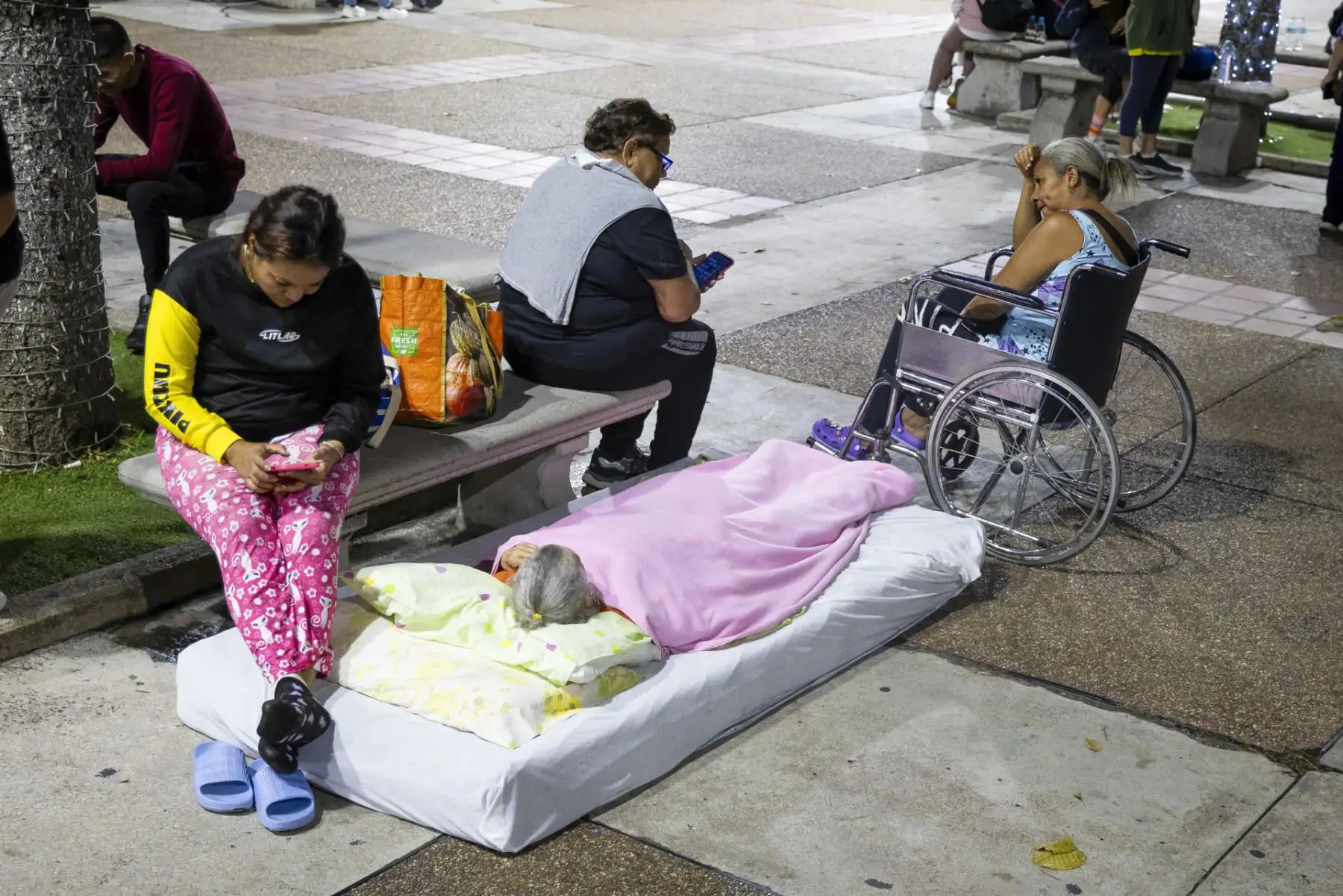 Varias personas permanecen al aire libre sobre colchones después de que los terremotos obligaran a numerosos habitantes a abandonar sus viviendas y pasar la noche en las calles. Foto: ANDINA/AFP.
