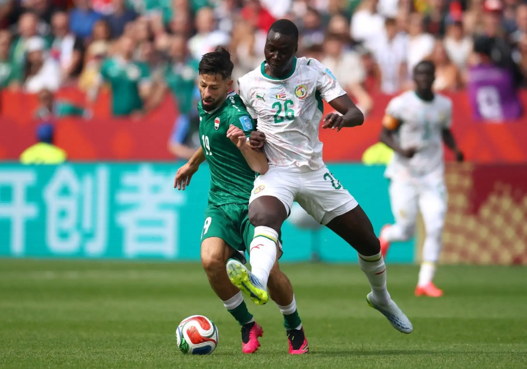 El centrocampista iraquí Kevin Yakob (número 19) y el centrocampista senegalés Pape Gueye (número 26) luchan por el balón durante el partido de fútbol del Grupo I de la Copa Mundial de 2026 entre Senegal e Irak en el Estadio de Toronto, el 26 de junio de 2026. (Foto de Cole Burston / AFP)