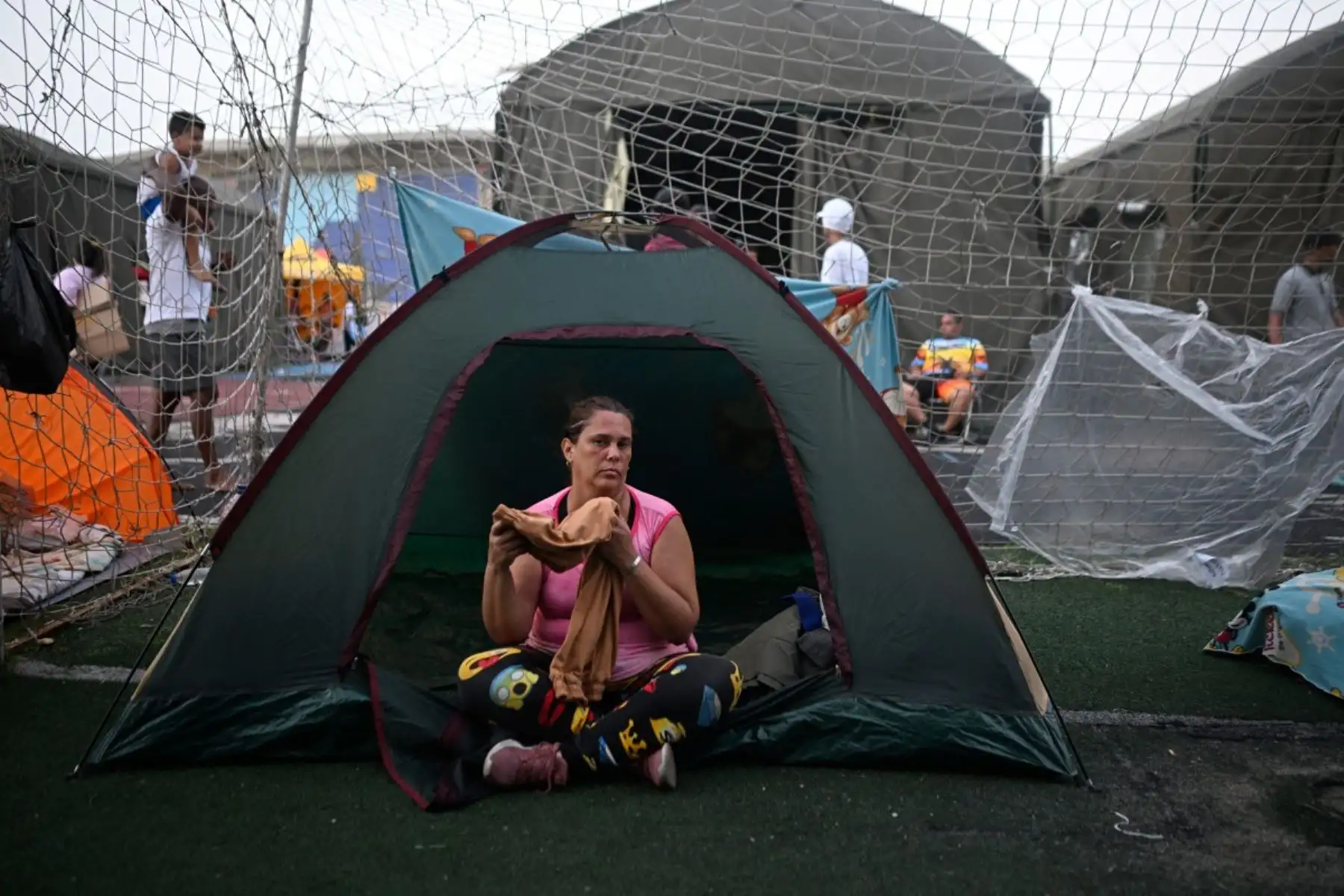 Una mujer se refugia en el complejo deportivo José María Vargas en Maiquetía, estado Vargas, Venezuela, el 26 de junio de 2026, tras los devastadores terremotos que azotaron el país. Foto: AFP