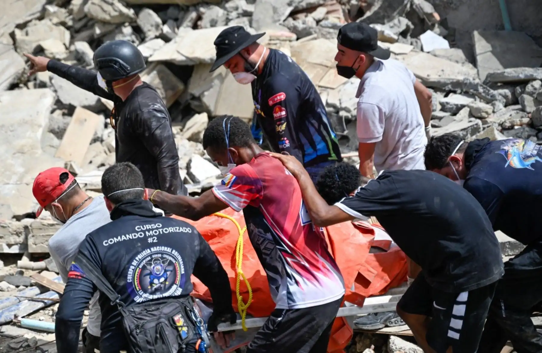 Miembros y voluntarios de Protección Civil venezolana recuperan un cuerpo en el lugar de los edificios derrumbados tras los terremotos en Caraballeda, estado de La Guaira, Venezuela, el 26 de junio de 2026. Foto: AFP