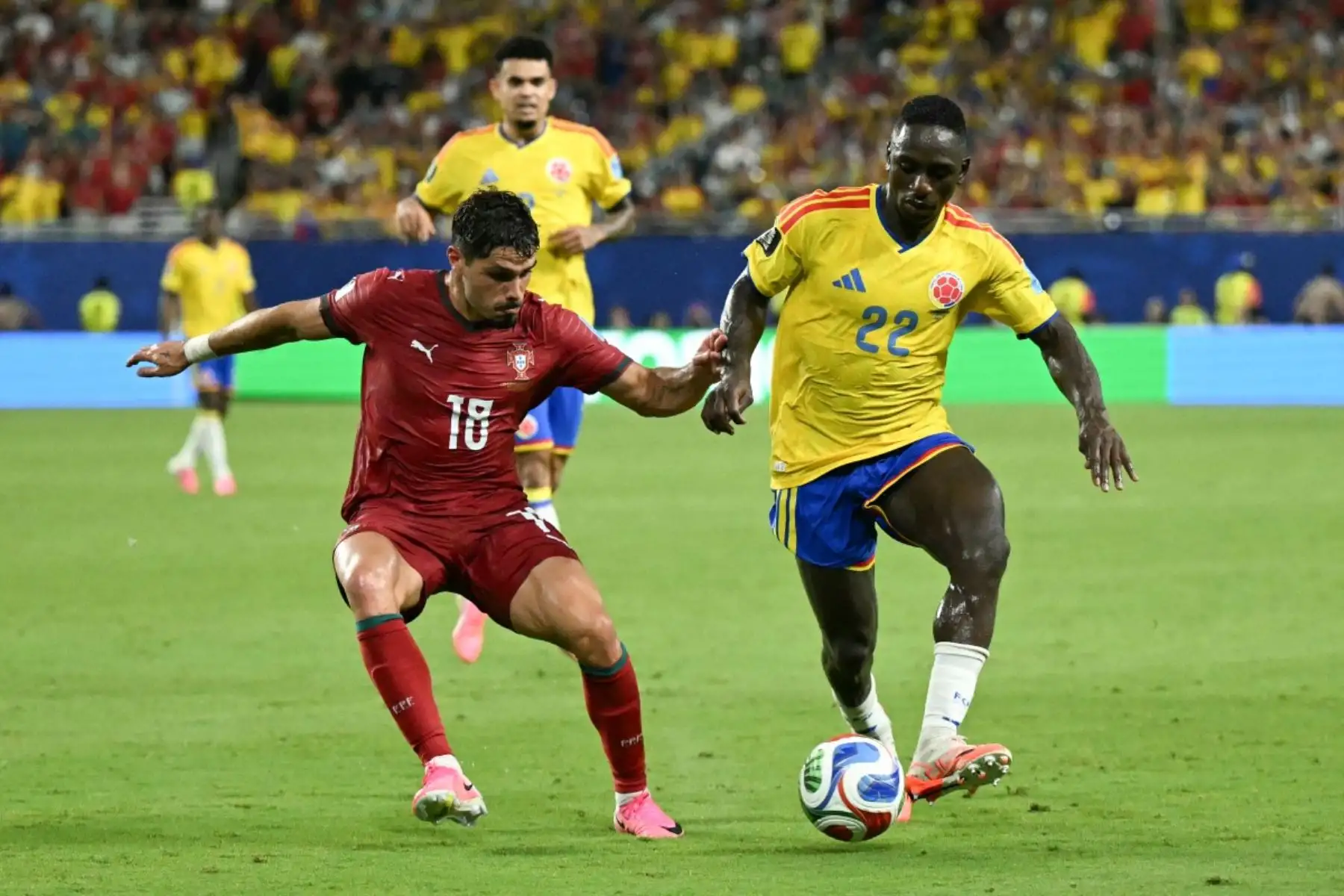 El delantero portugués Pedro Neto (número 18) y el defensa colombiano Deiver Machado (número 22) luchan por el balón durante el partido de fútbol del Grupo K del Mundial 2026 entre Colombia y Portugal en el Miami Stadium de Miami Gardens el 27 de junio de 2026. (Foto de CHANDAN KHANNA / AFP)