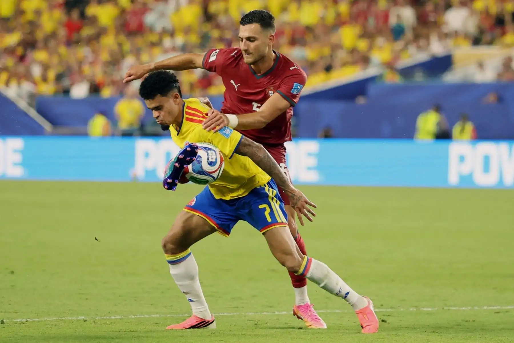 El delantero colombiano Luis Díaz (n.º 07) y el defensa portugués Diogo Dalot (n.º 05) luchan por el balón durante el partido de fútbol del Grupo K del Mundial 2026 entre Colombia y Portugal en el Miami Stadium de Miami Gardens el 27 de junio de 2026. (Foto de PATRICIA DE MELO MOREIRA / AFP)