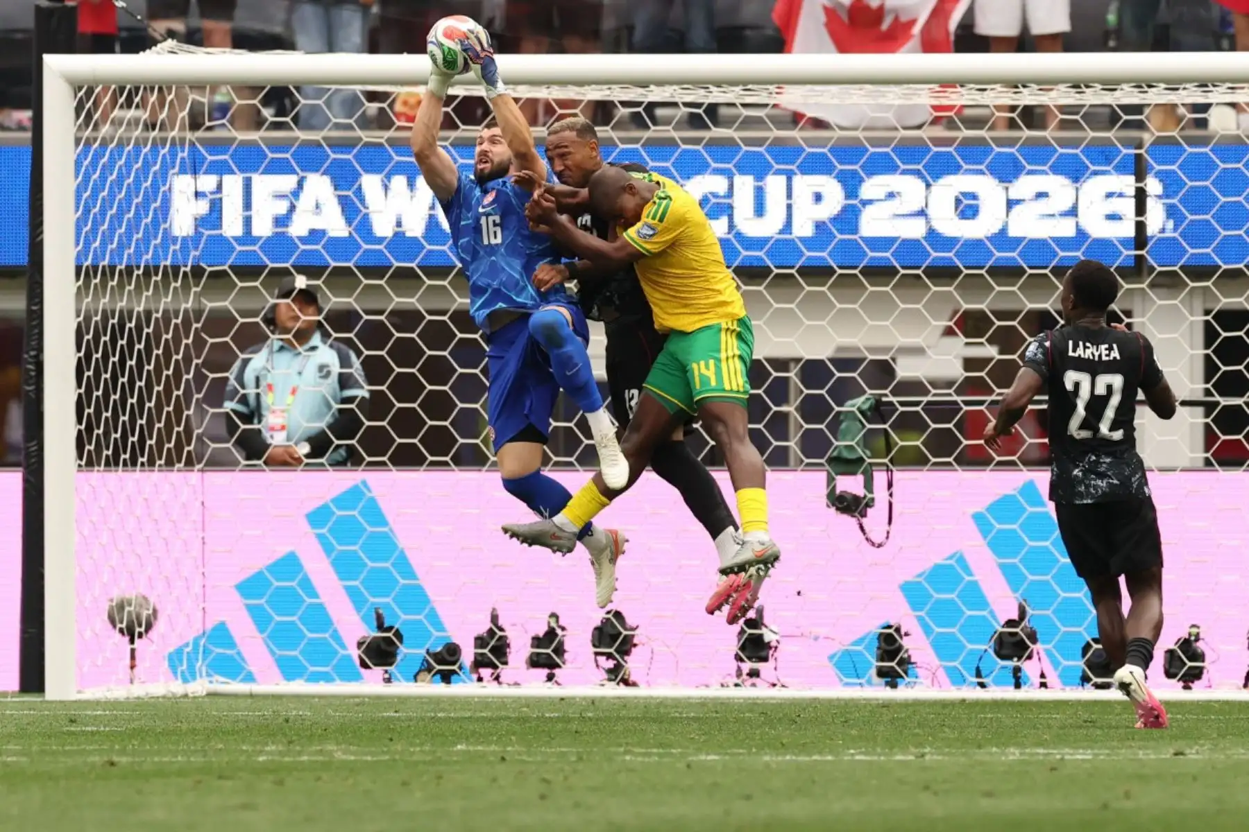 El portero canadiense número 16, Maxime Crepeau, realiza una parada ante el defensa canadiense número 13, Derek Cornelius, y el defensa sudafricano número 14, Mbekezeli Mbokazi, durante el partido de dieciseisavos de final de la Copa Mundial de 2026 entre Sudáfrica y Canadá en el Estadio de Los Ángeles en Inglewood, el 28 de junio de 2026. (Foto de ETIENNE LAURENT / AFP)