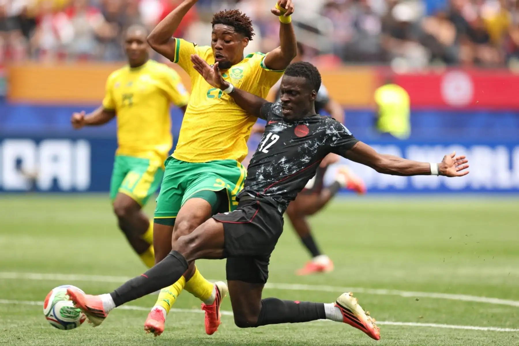 El delantero canadiense número 12, Tani Oluwaseyi, patea el balón y falla una oportunidad de gol ante el defensor sudafricano número 21, Ime Okon, durante el partido de dieciseisavos de final de la Copa Mundial de 2026 entre Sudáfrica y Canadá en el Estadio de Los Ángeles en Inglewood, el 28 de junio de 2026. (Foto de ETIENNE LAURENT / AFP)