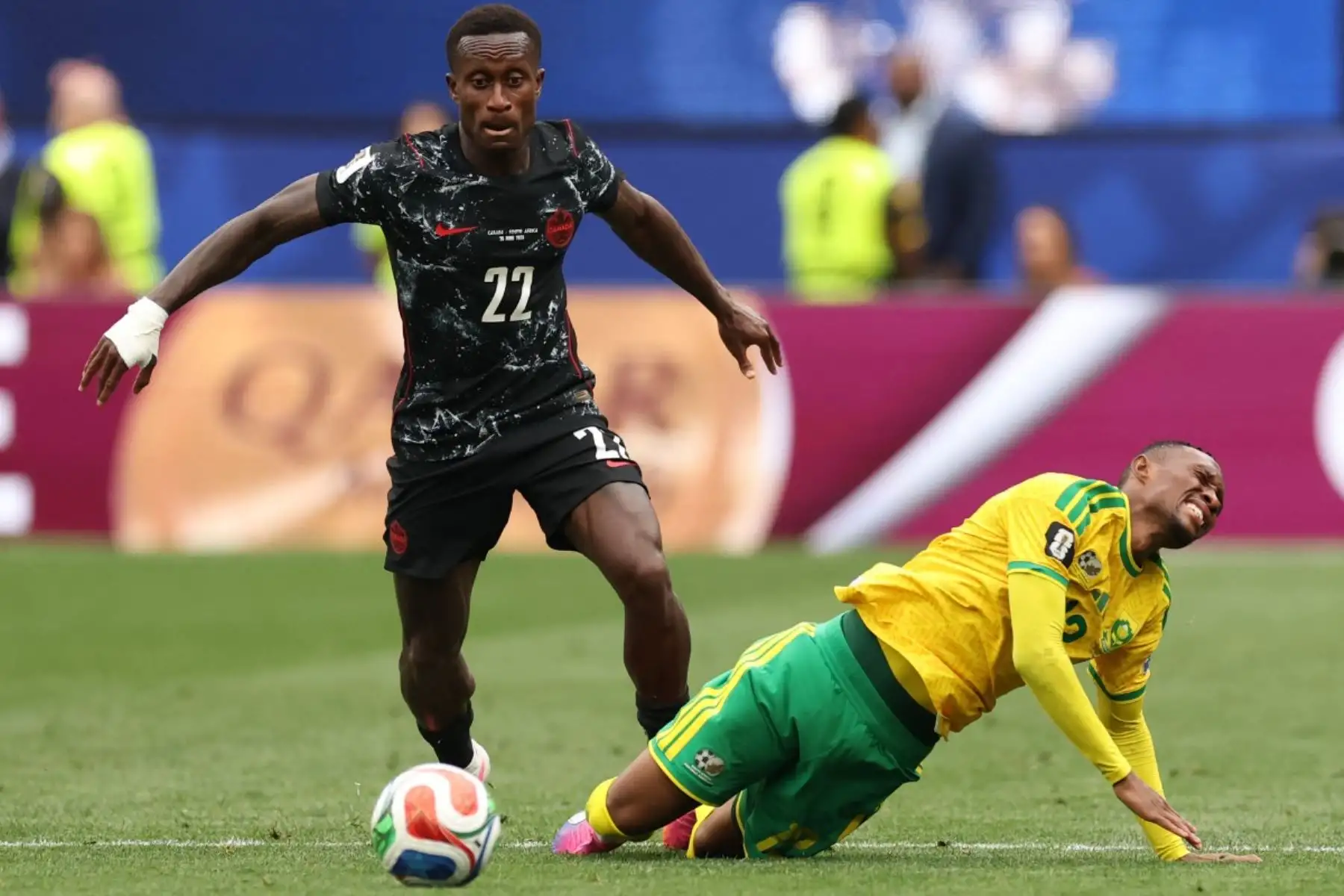 El delantero sudafricano Thapelo Maseko (derecha), número 12 del ranking, cae al suelo tras superar al defensor canadiense Richie Laryea, número 22, durante el partido de dieciseisavos de final del Mundial de 2026 entre Sudáfrica y Canadá, disputado en el estadio de Los Ángeles en Inglewood el 28 de junio de 2026. (Foto de ETIENNE LAURENT / AFP)