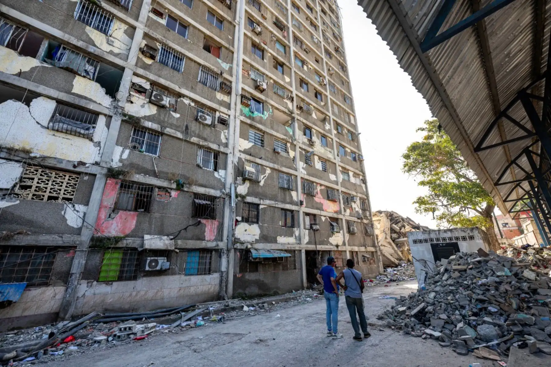 Habitantes de la zona permanecen junto a un edificio dañado en Catia La Mar, estado de La Guaira, Venezuela. Foto: AFP