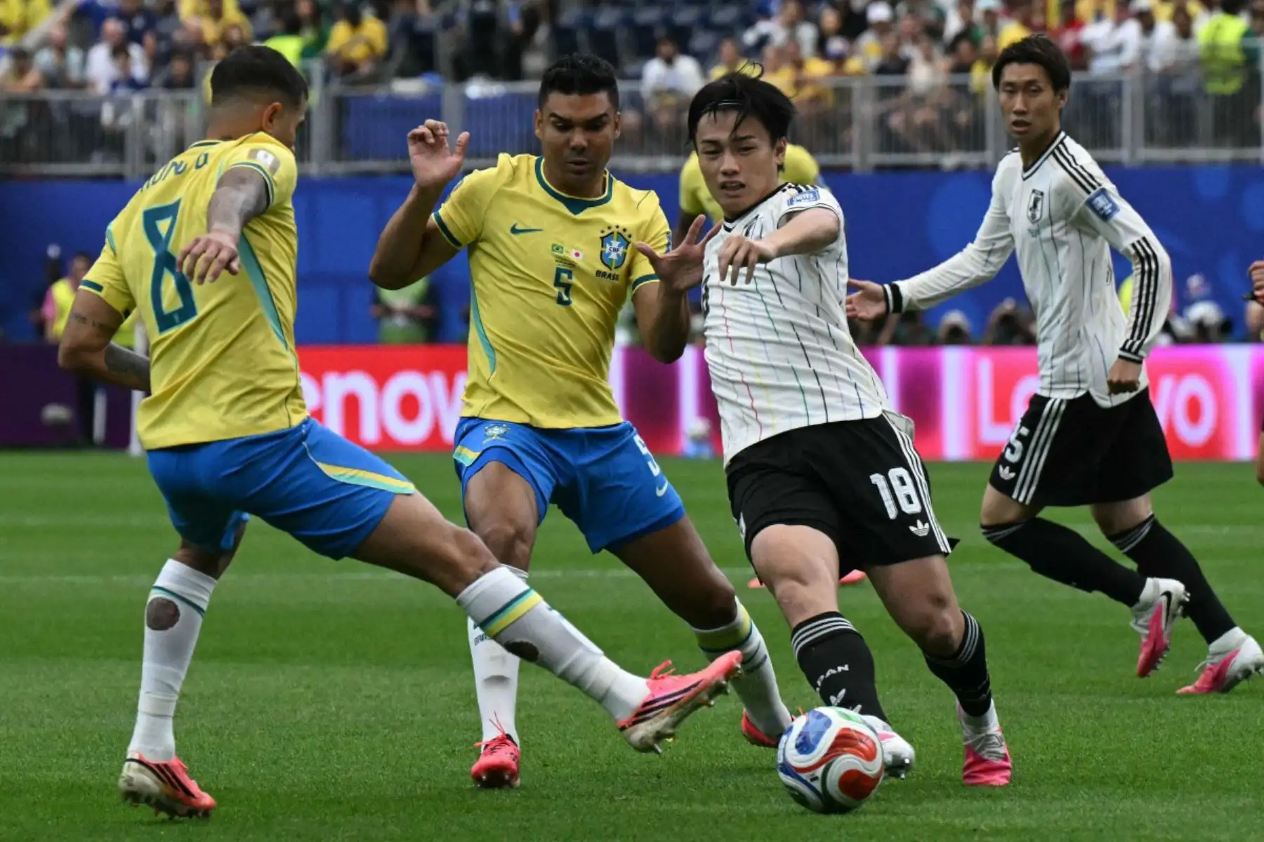El centrocampista brasileño Bruno Guimarães y el centrocampista brasileño Casemiro disputan el balón con el delantero japonés n.º 18 Ayase Ueda (segundo por la derecha) en el estadio de Houston. Foto: AFP