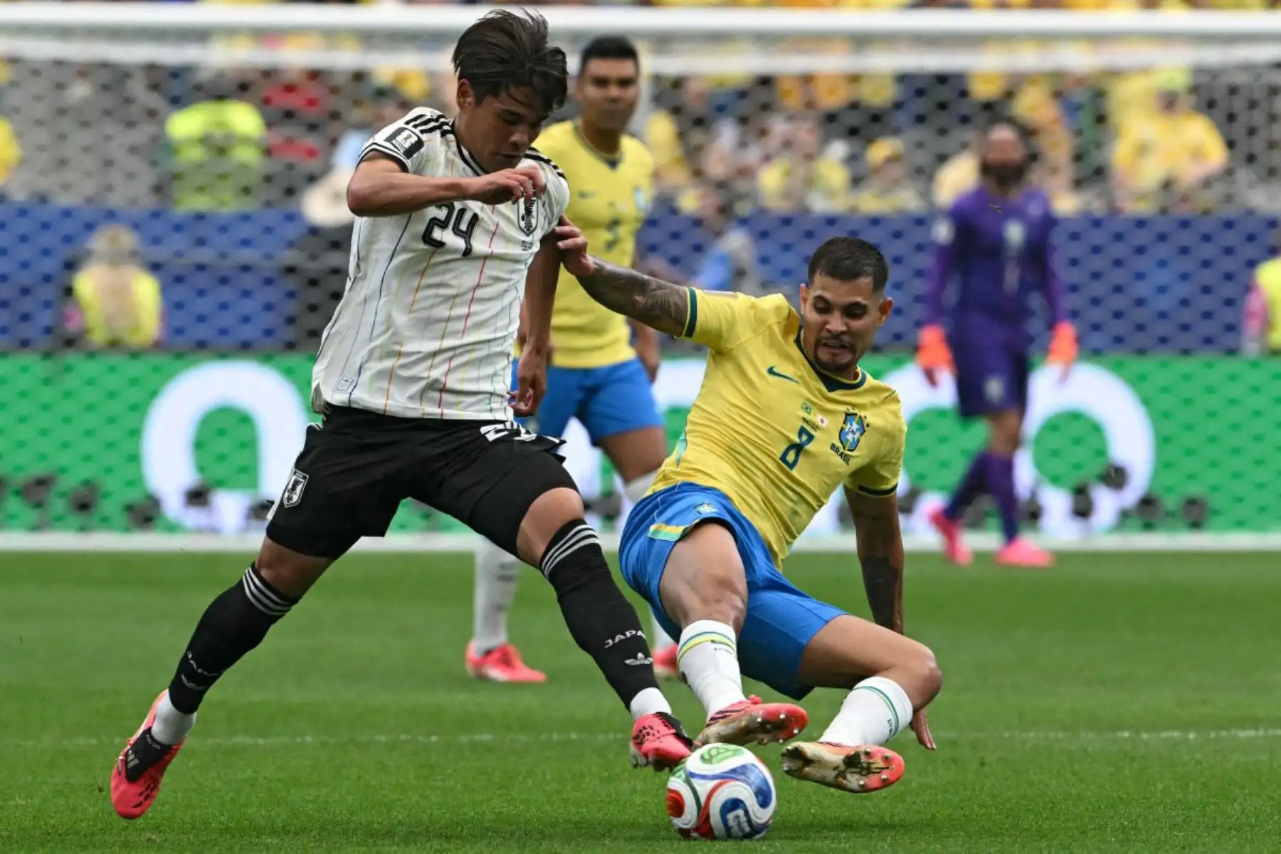 El centrocampista japonés Kaishu Sano disputa el balón con el centrocampista brasileño Bruno Guimaraes en el estadio de Houston. Foto: AFP