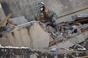 Un integrante de equipos de rescate de México realiza labores de búsqueda en los escombros de un edificio colapsado por terremotos en Venezuela. Foto: EFE