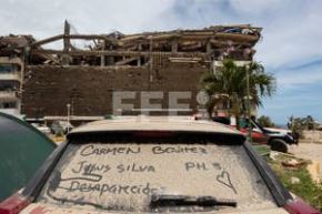 Detalle del vidrio panorámico de un automóvil cubierto de polvo y con los nombres de personas desaparecidas durante los terremotos del pasado miércoles, en Catia La Mar, Venezuela. Foto: EFE/Ronald Peña
