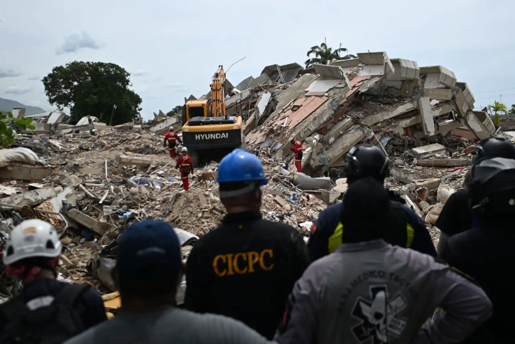 Voluntarios y paramédicos permanecen inmóviles mientras los rescatistas realizan pruebas de sonido en busca de sobrevivientes tras los dos terremotos del 24 de junio en Caraballeda, estado de La Guaira, Venezuela, el 30 de junio de 2026. Foto: AFP