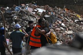 Familiares de personas desaparecidas se abrazan junto a los escombros en la playa Los Cocos, en Caraballeda (estado de La Guaira, Venezuela). Foto: AFP
